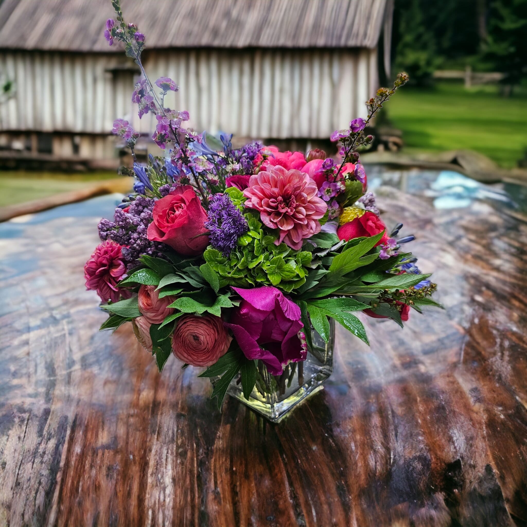 The Colors of Passion - Rich vibrant colors of deep pinks, purples, blues and greens featuring the freshest flowers available, in a low land lush design in a crystal clear cube. *** Please note that certain flowers like Dahlias and Peonies are not readily available all the time and are restricted to their season. ***