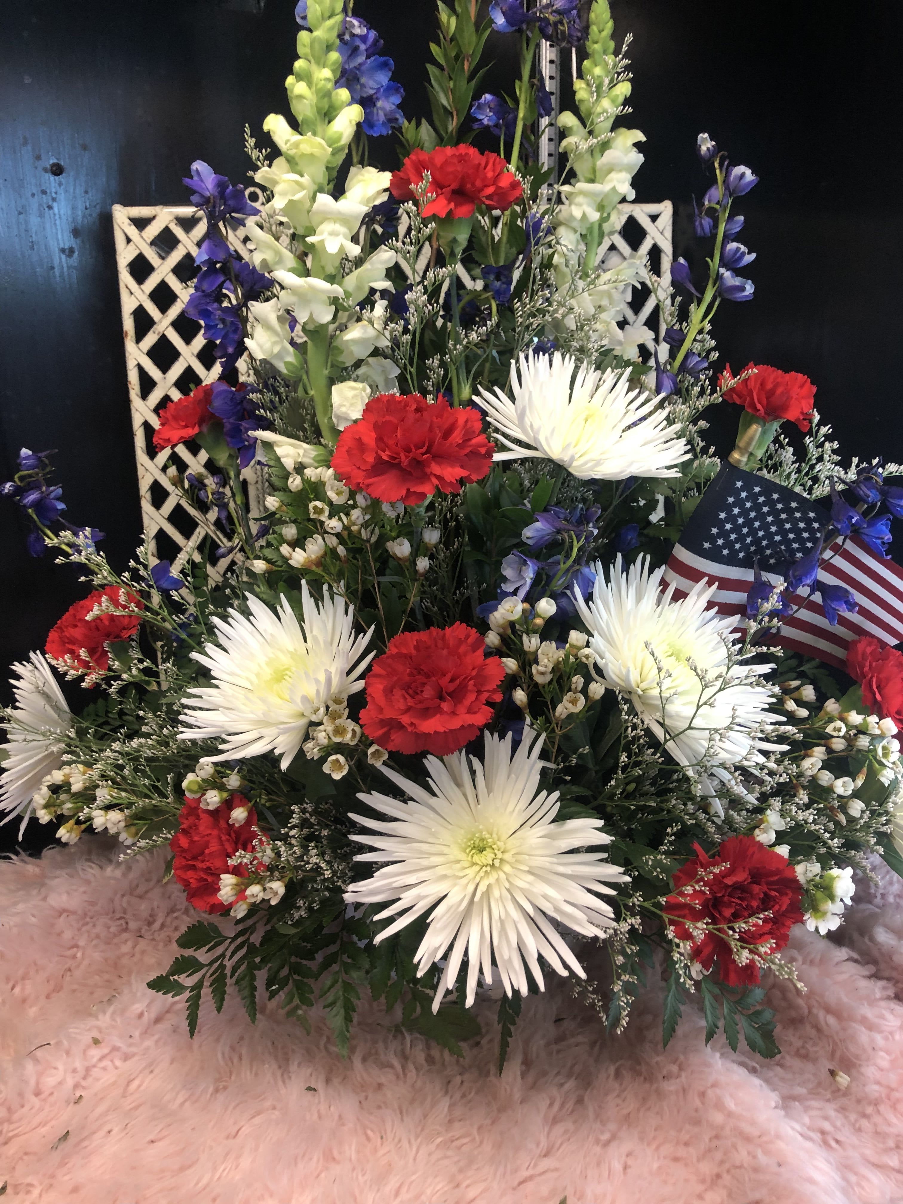 Glory Glory - Red carnations, whiye spides, blue delphinium, white snapdragons, in blue glass cube.