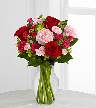 The FTD® Love is Grand™ Bouquet - B18B-4948  The FTD® Love is Grand™ Bouquet brings together everyone's favorite blooms to celebrate the love you share with your special someone. Brilliant red roses are surrounded by hot pink spray roses, pink carnations and pink mini carnations to create a fantastic flower arrangement. Presented in a classic clear glass vase, this mixed flower bouquet will send your sweetest wishes to your special someone.