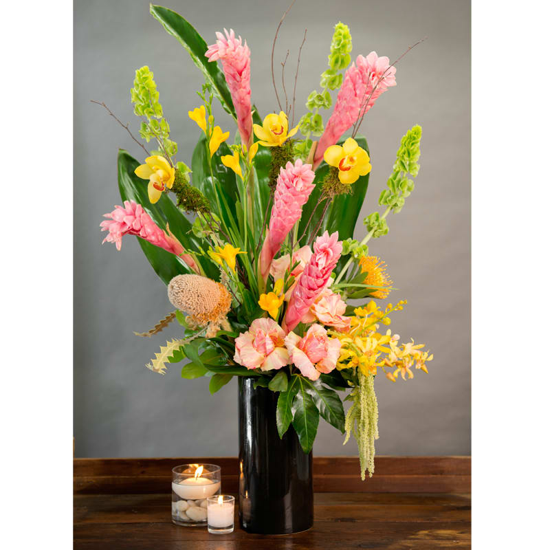A TOUCH OF HAWAII A TOUCH OF HAWAII - PINK HAWAIIN GINGER, PROTEA, ECUADORIAN ROSES, BELLS OF IRELAND, YELLOW FREESIA, YELLOW ORCHIDS IN A BLACK CERAMIC VASE