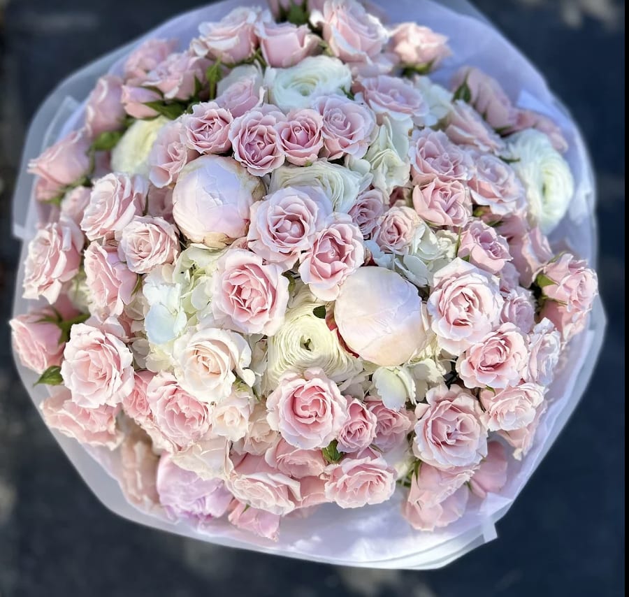 Pink Elegance - Soft and romantic, the Blush Elegance Bouquet features delicate spray pink roses, ranunculus, and peonies. This luxurious round arrangement is perfect for weddings, anniversaries, or any occasion that calls for timeless elegance and tender affection.   