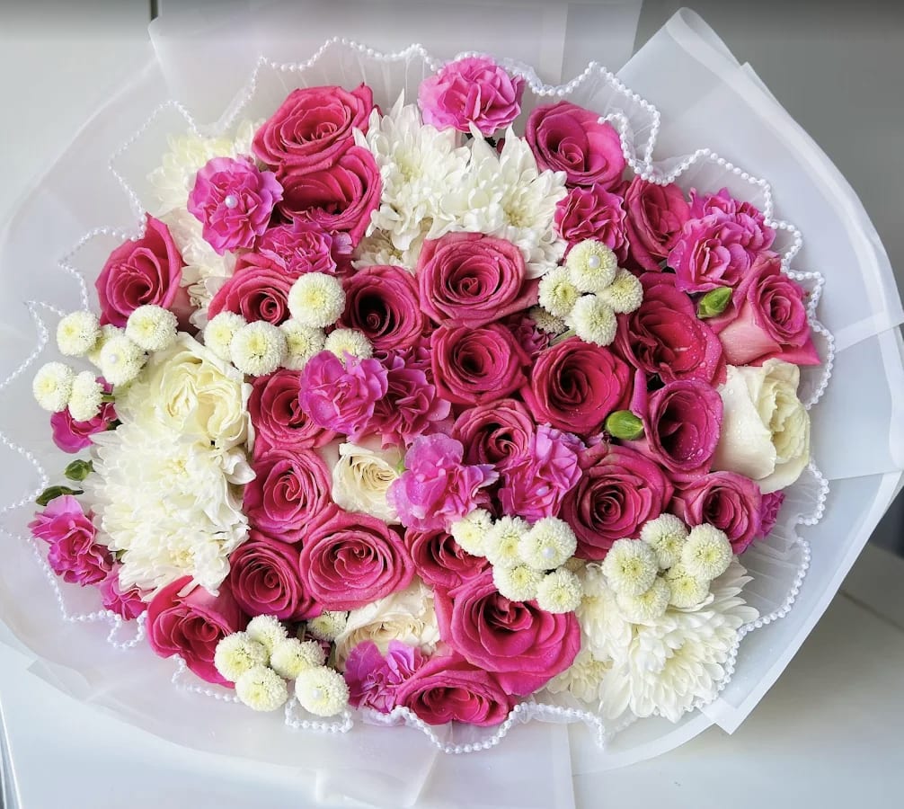 Royal pink bouquet - A vibrant blend of deep pink roses, hot pink carnations, white chrysanthemums, and playful button daisies. This eye-catching bouquet is full of passion and joy — perfect for birthdays, celebrations, or simply brightening someone's day.  Wrapped with waterproof wrapping paper