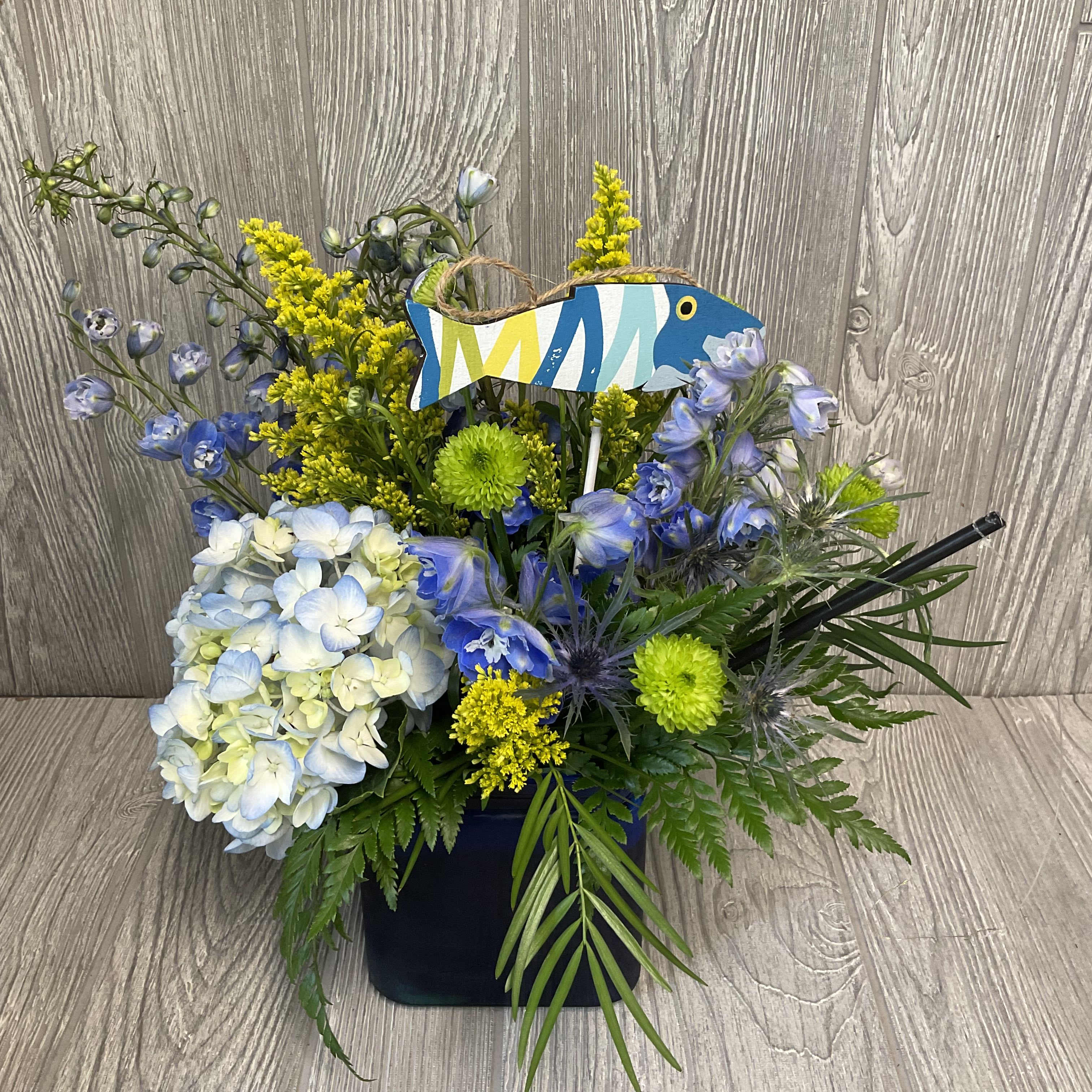 Gone Fishin’ - Let this arrangement of fresh cut flowers transport you to your favorite fishing spot, from the comfort of your home. Flowers and colors may vary. 