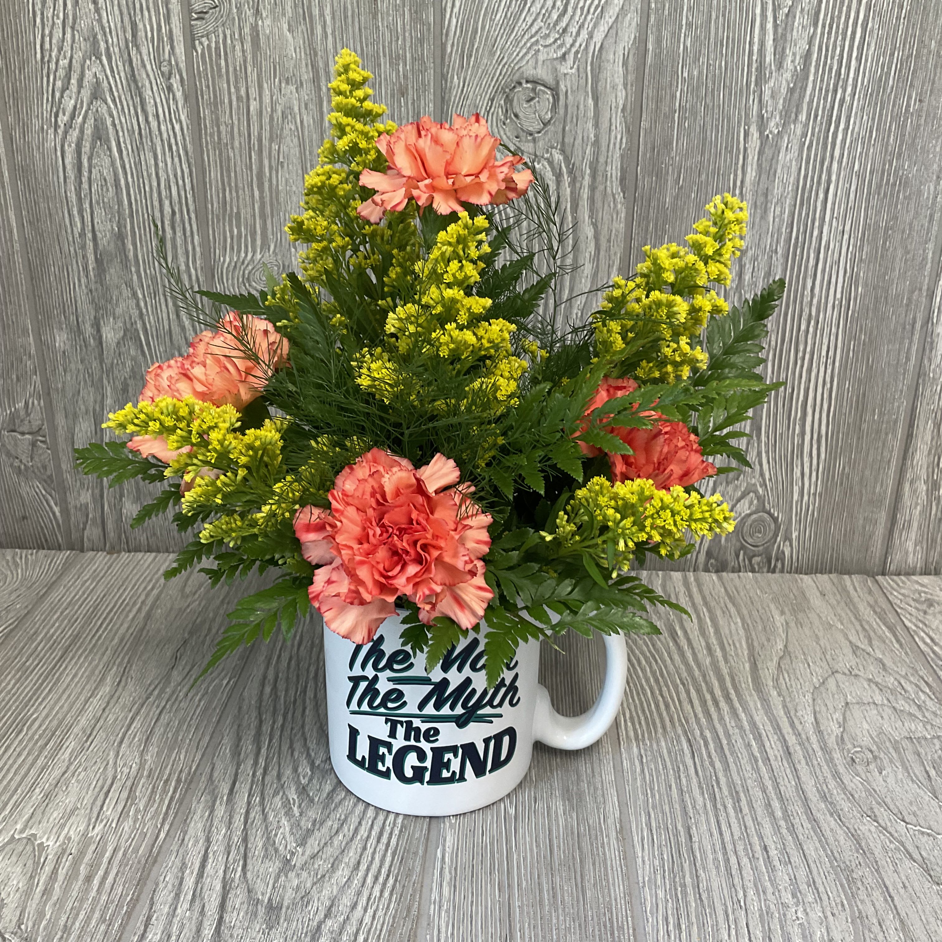 The Man, The Myth, The Legend Mug - Fresh cut flowers in a keepsake ceramic mug. Flowers and colors may vary. 
