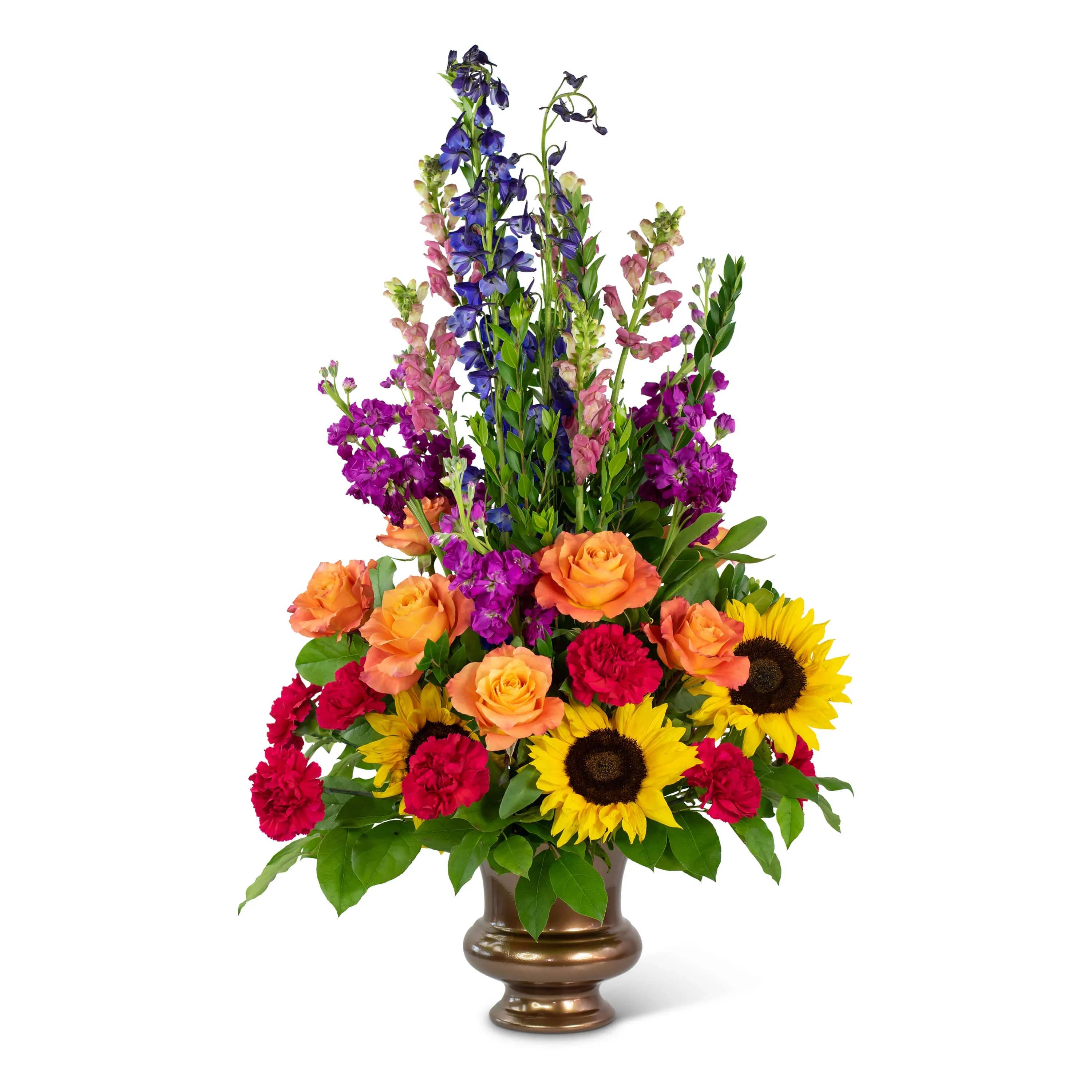 Prismatic Rays Tribute Prismatic Rays Tribute - Celebrate vivid memories with The Prismatic Rays Tribute. Carnations, Snapdragons, Stock, Delphinium, Sunflowers and Roses convey your wishes of sympathy and comfort to the grieving family.