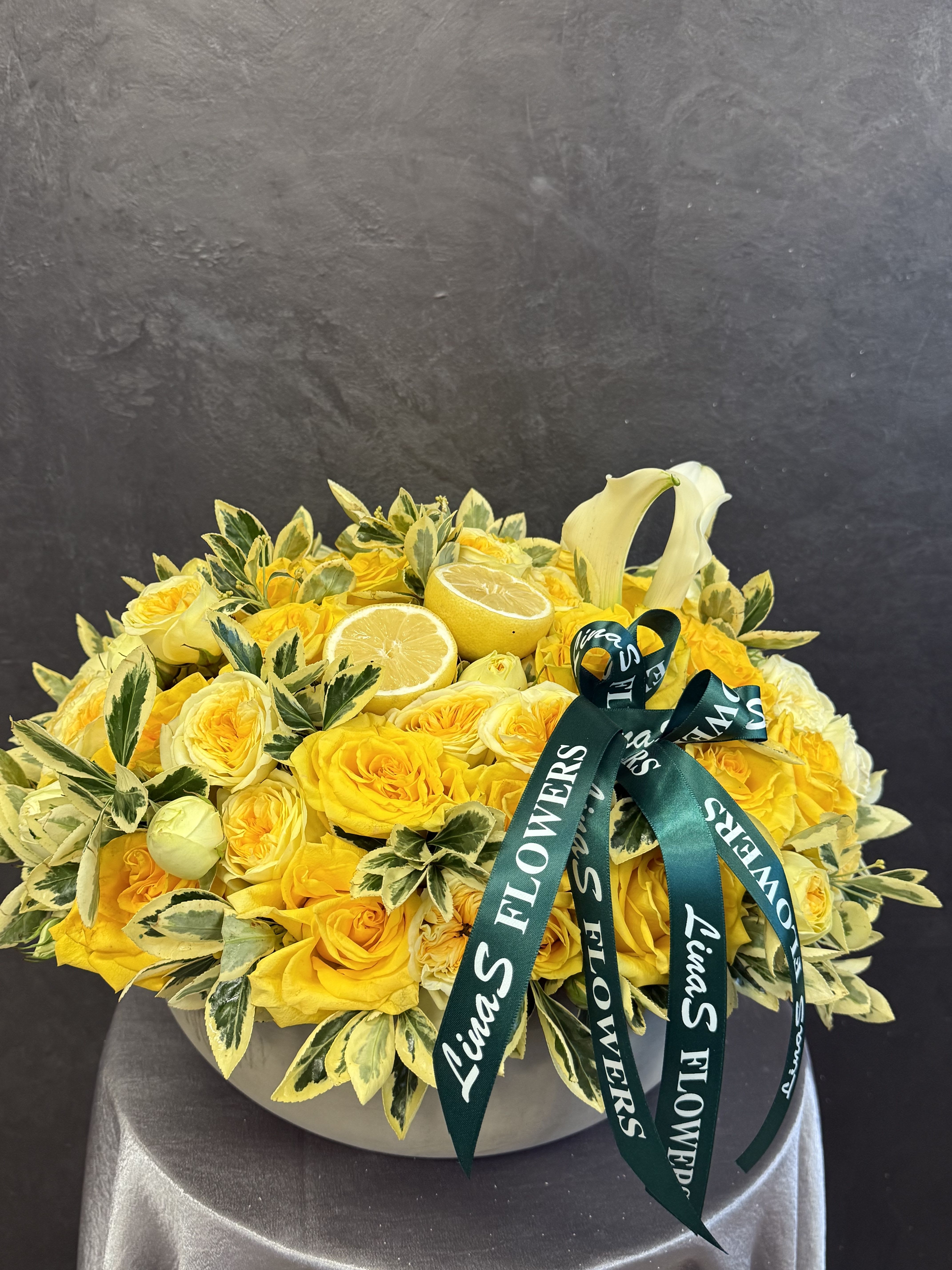Yellow Yellow - Short Description: Bright yellow roses paired with fresh lemons create a cheerful and vibrant display, symbolizing friendship, joy, and positivity.