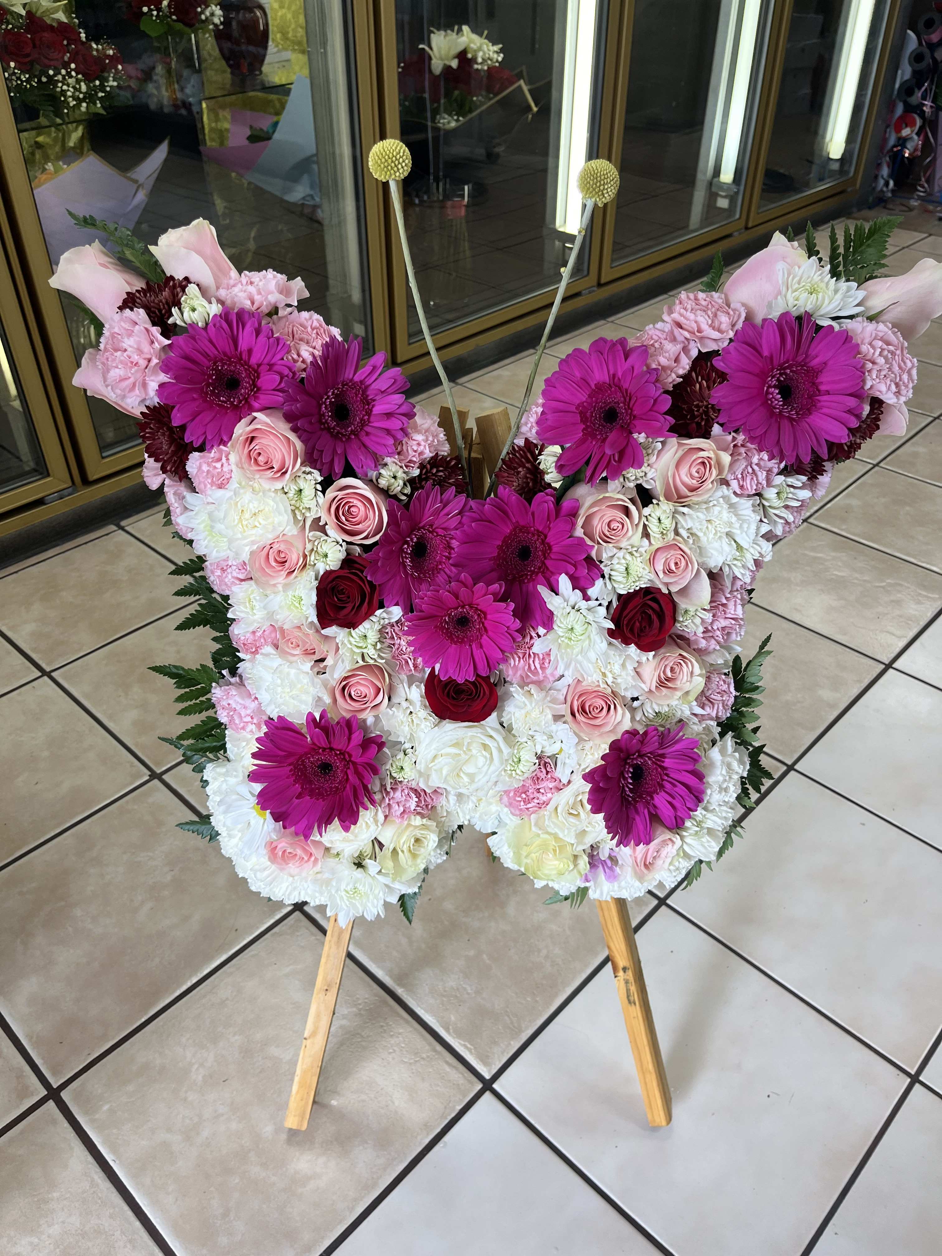 Butterfly Spray - Butterfly sympathy spray contains roses, gerbera daisies carnations in a butterfly shape. 