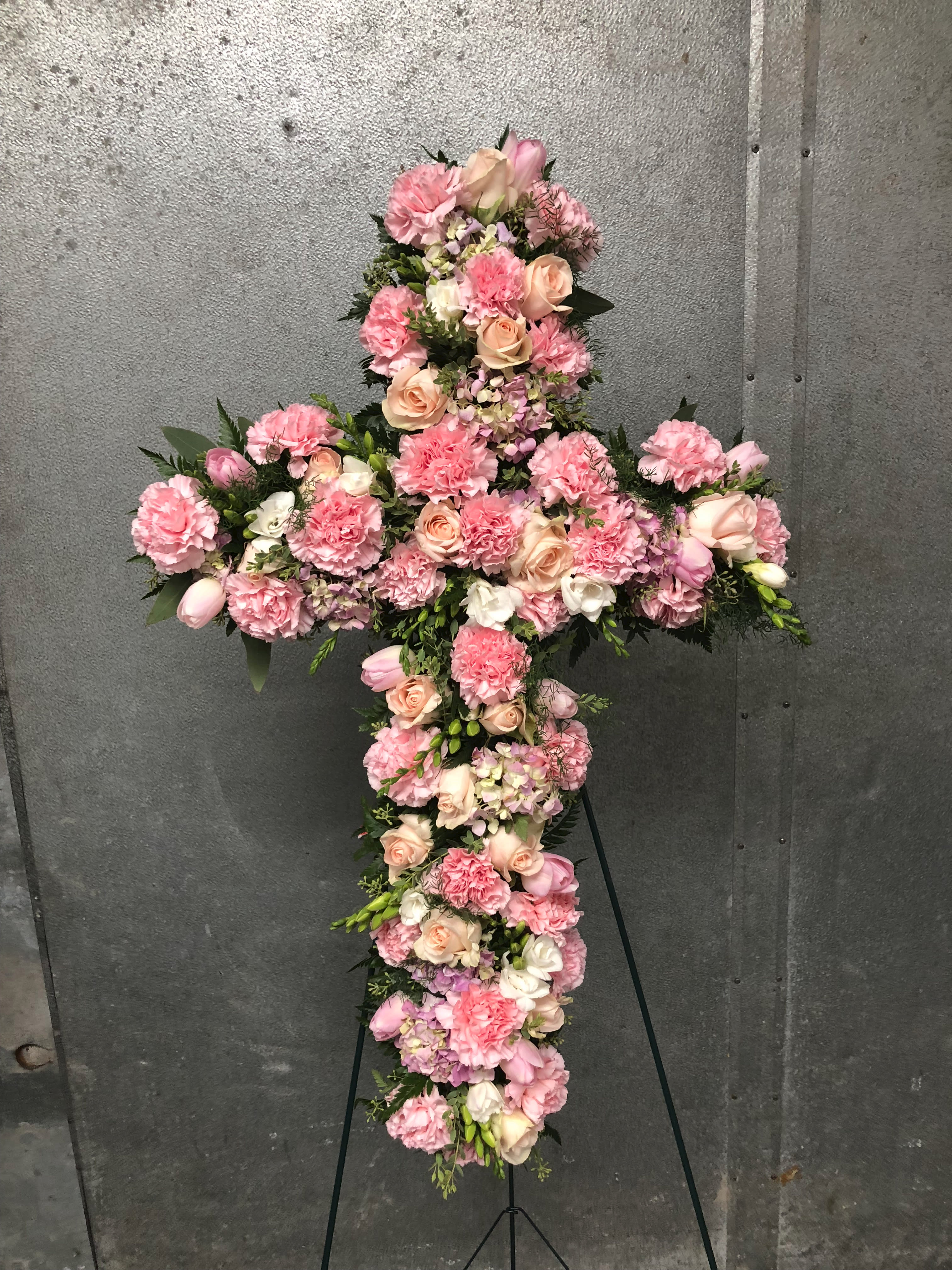Pink and Peach Cross Pink and Peach Cross - Peach garden roses and Pink Carnations line this cross for a beautiful tribute to your loved one. Depending on the seasonality of the flowers available, the designer also adds pink tulips and white freesia The textures and colors are striking.