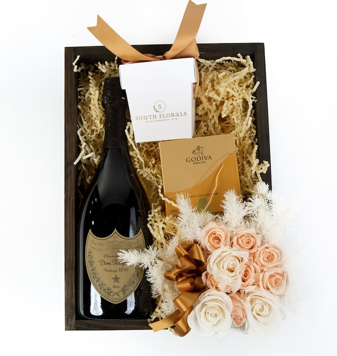 Dom Perignon Luxurious Gift Box Dom Perignon Luxurious Gift Box - GBDP - Dom Perignon Luxurious Gift Box The Dom Perignon Luxurious Gift Box includes a bottle of Vintage Brut Dom Perignon Champagne, 8pc Godiva Chocolate, Scented Candle Wrapped in Satin Ribbons, Preserved Roses on a bed of French Vanilla shred. The Preserved Roses are frozen in time and will remain as a beautiful keepsake.