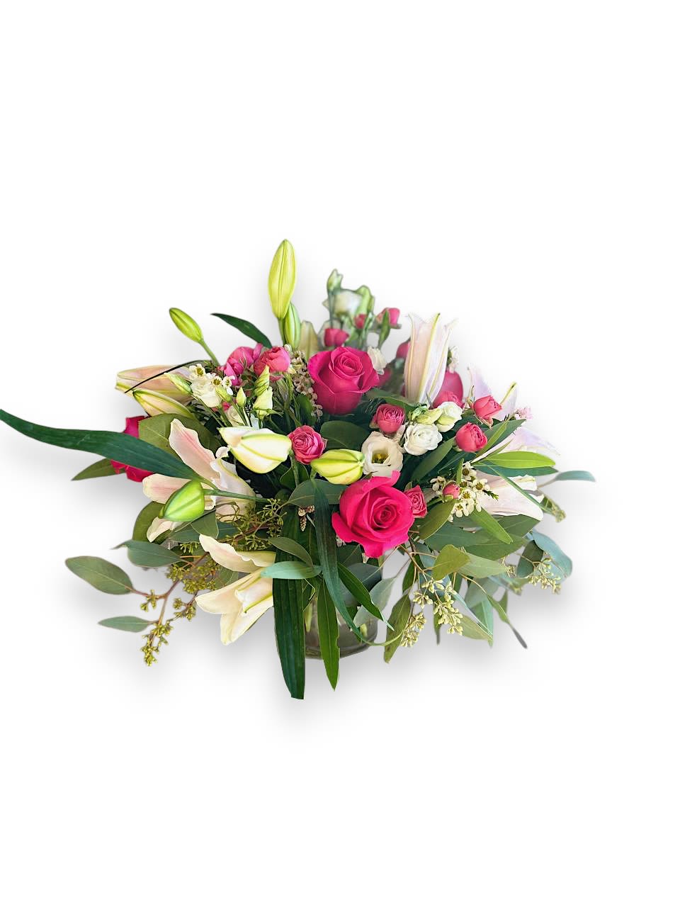 Pink Centerpiece  - This gorgeous centerpiece showcases hot pink roses, light pink lilies and white lisianthus. Accentuated with seeded eucalyptus and wax flower, this low and round arrangement is the perfect choice for any event. 