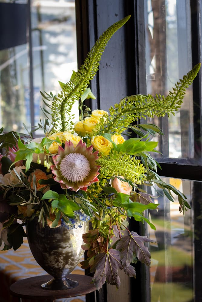 Royal  - A grand bouquet of protea with other seasonal flowers that have soft and gentle hues. Branchy green stems that arc above make a tall and and eye catching arrangement. 