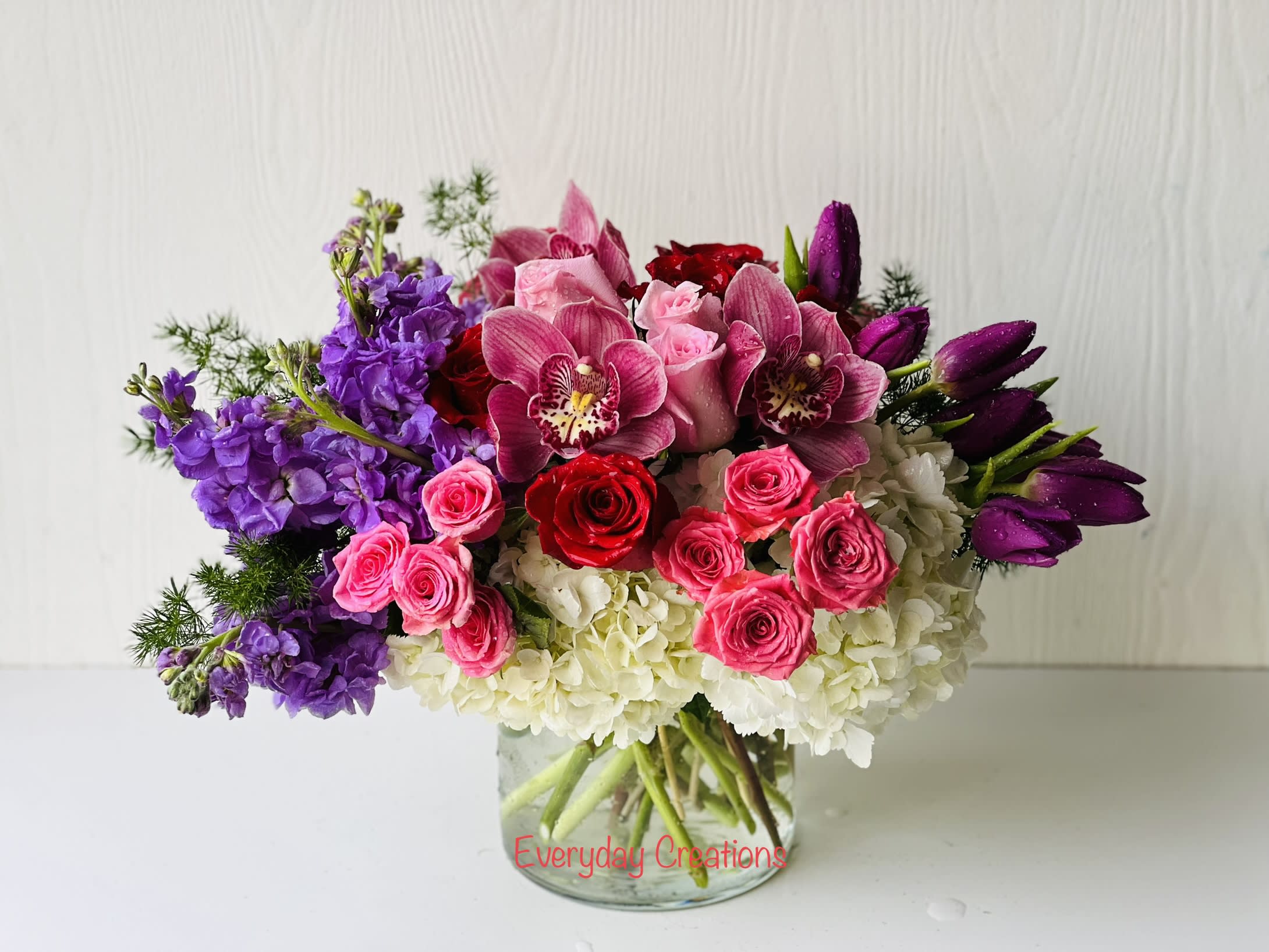 EC01 - Garden Romance EC01 - Garden Romance - Endulge in the perfect expression of romance with the Garden Romance bouquet. This beautiful flower arrangement features purple stock, pink spray roses, purple tulips, pink and red roses, and pink cimbidium orchids that are expertly arranged to create an unforgettable display of beauty and love. The striking combination of bold purples and pinks and reds in this bouquet creates a true harmonious and romantic atmosphere. Purple stock represents everlasting love and prosperity, while pink and red roses symbolize passion and desire. This romantic and charming statement piece is perfect for special occasions such as Valentine's day, anniversaries, or as a meaningful gesture of love and affection.