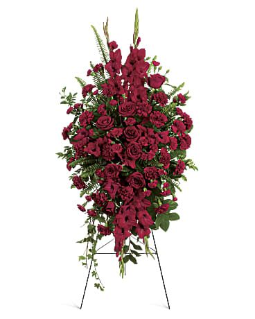 Deep in Our Hearts Spray - At FloristMarketplace, express your heartfelt sympathies with this magnificent spray of all-red floral favorites. It’s a vibrant and beautiful tribute that helps ease the pain of loss.  This radiant arrangement features red roses, red gladioli, red carnations, and red miniature carnations, all beautifully accented with assorted greenery.  Orientation: One-Sided.