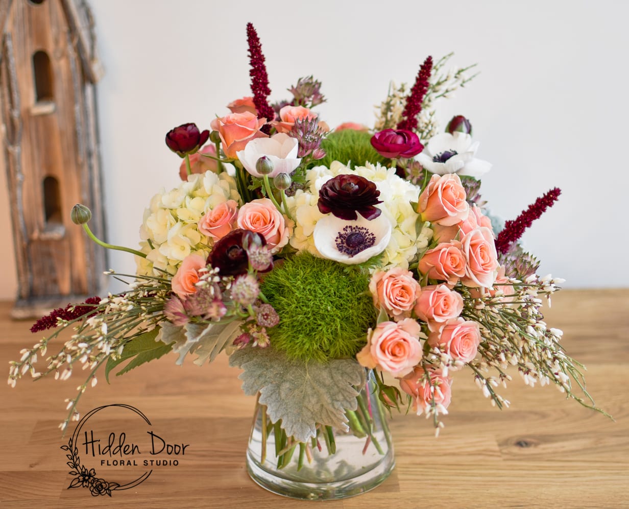 Santa Monica Santa Monica - Immerse yourself in the beauty of this modern floral design, carefully curated to evoke a sense of elegance and contemporary style. The arrangement showcases a delightful combination of pristine white hydrangeas, delicate pink spray roses, and lush green dianthus. We have added a touch of whimsy and playfulness to further enhance this floral art. We've included gorgeous white anemones that dance like ocean waves. The whole arrangement gives you a sense of flowing florals. Santa Monica is presented in a sleek and clear vase, allowing the vibrant hues of the blooms to take center stage. Adorned with seasonal greens and additional accents such as white or light pink wax flowers, this arrangement exudes an air of sophistication while maintaining a touch of natural beauty. With its medium size, Santa Monica is the perfect choice for various occasions. It serves as a charming everyday gift designed to bring wonder and joy into the lives of loved ones. Additionally, its elegant design makes it a splendid choice for private and corporate parties, adding a touch of coastal elegance to any event. Picture Santa Monica gracing wedding receptions with its modern allure, effortlessly complementing the celebratory atmosphere.