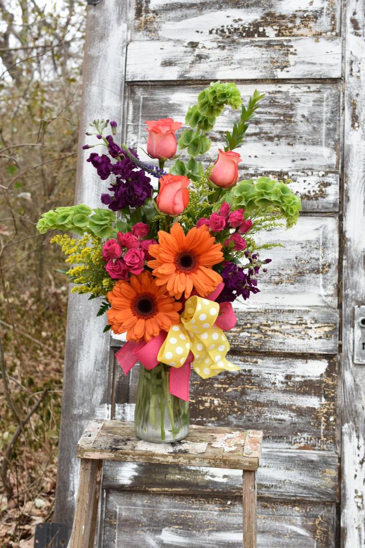 Bold and Beautiful - A stunning design full of colorful flowers. Gerbera daisies, bells of Ireland, stock, roses, and spray roses come together in this arrangement to put a smile on your loved one's face!