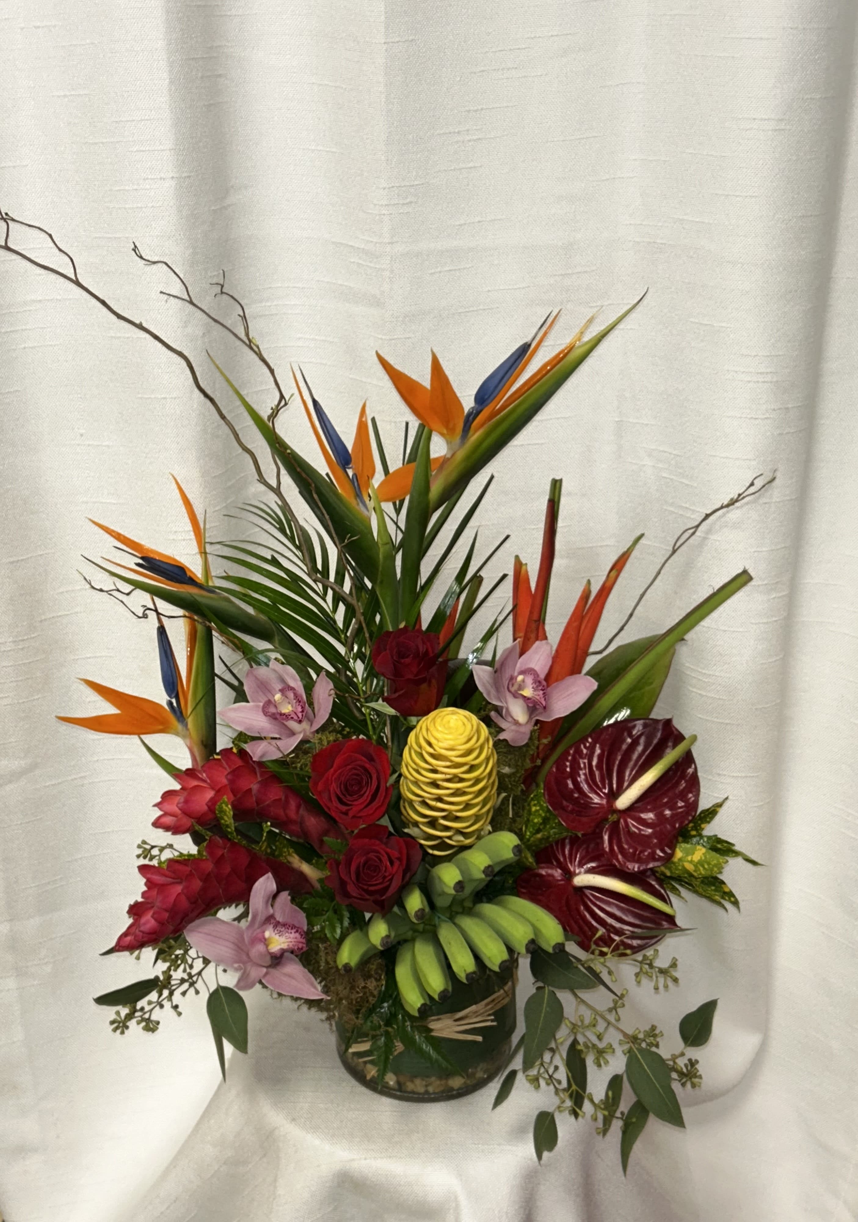 Tropical Madness (DB) - Escape to a tropical paradise with our stunning Tropical Madness flower arrangement featuring the vibrant and exotic beauty of Birds of paradise, Orchids, Anthuriums, Ginger, Protea, and more. Available for same-day delivery in Boca Raton, our tropical masterpiece is guaranteed to bring a sense of joy and excitement into any space.