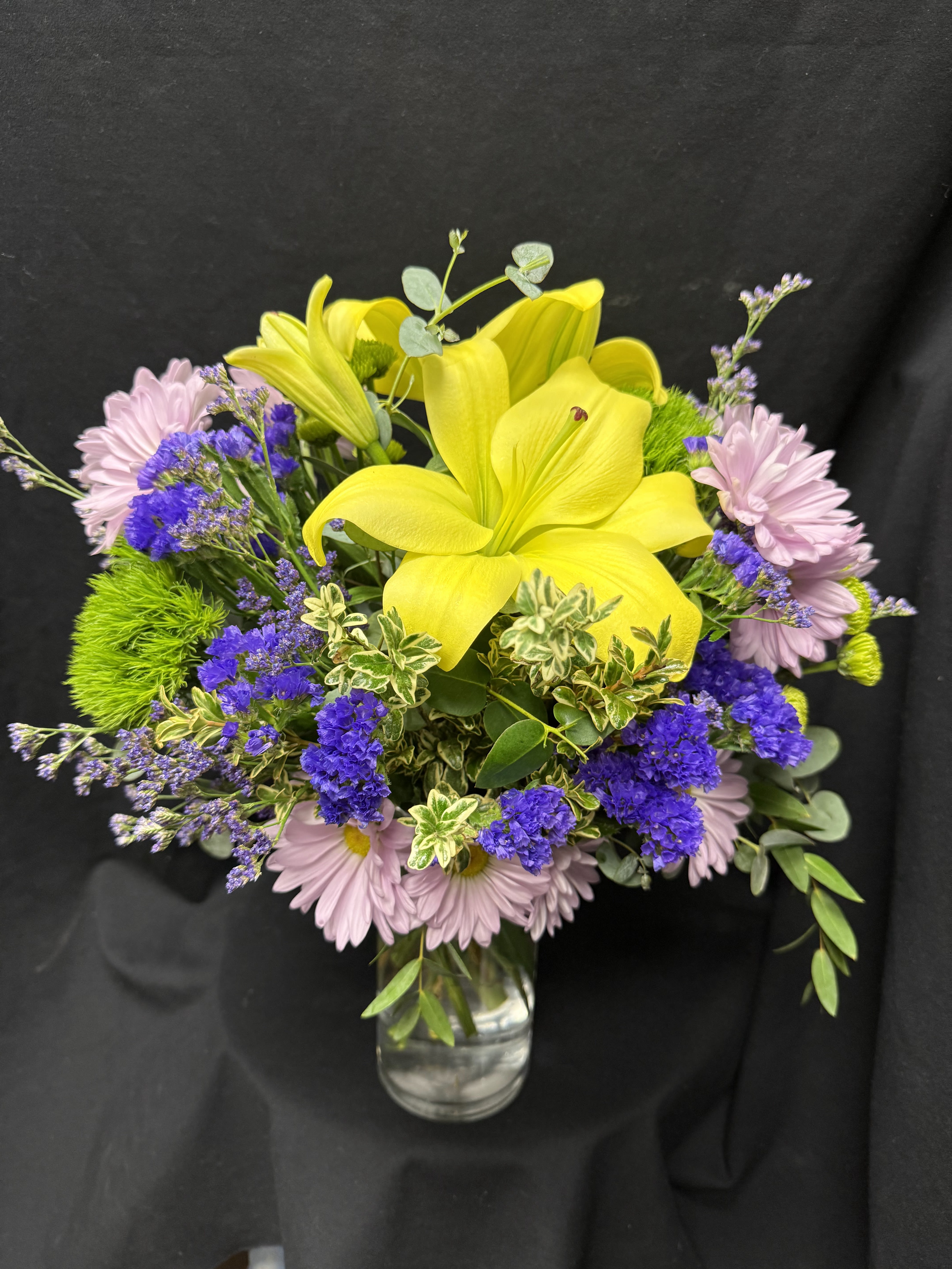 Lemon mix - Vase filled with yellow siatic lilies, lavender daisies and limonium, purple statice sinuata  and mixed greens.