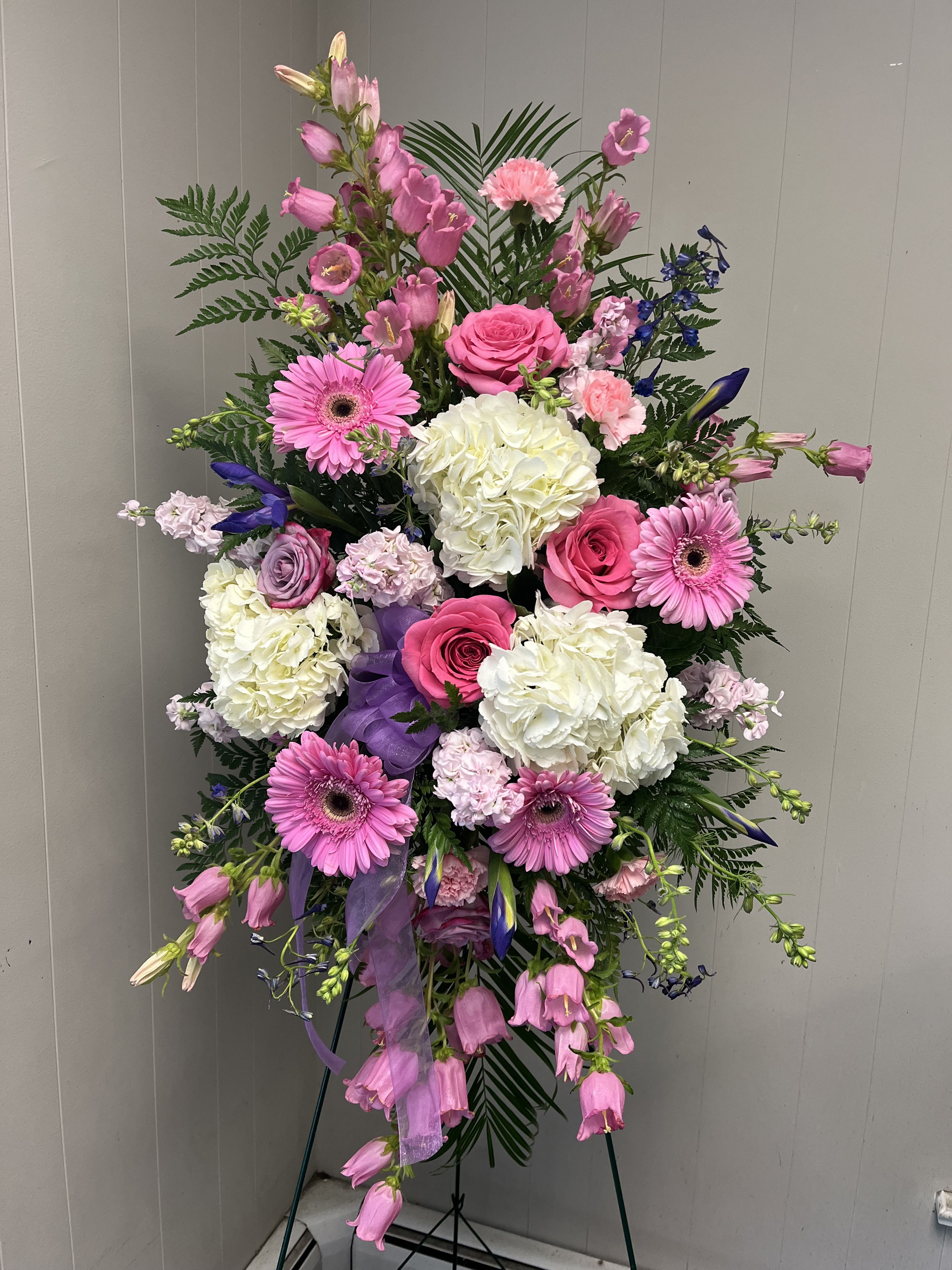 Pink, white and lavender standing spray  - Designers choice of shades of pink, white, and lavender flowers arranged in a standing spray. We will use the freshest flowers available that day.