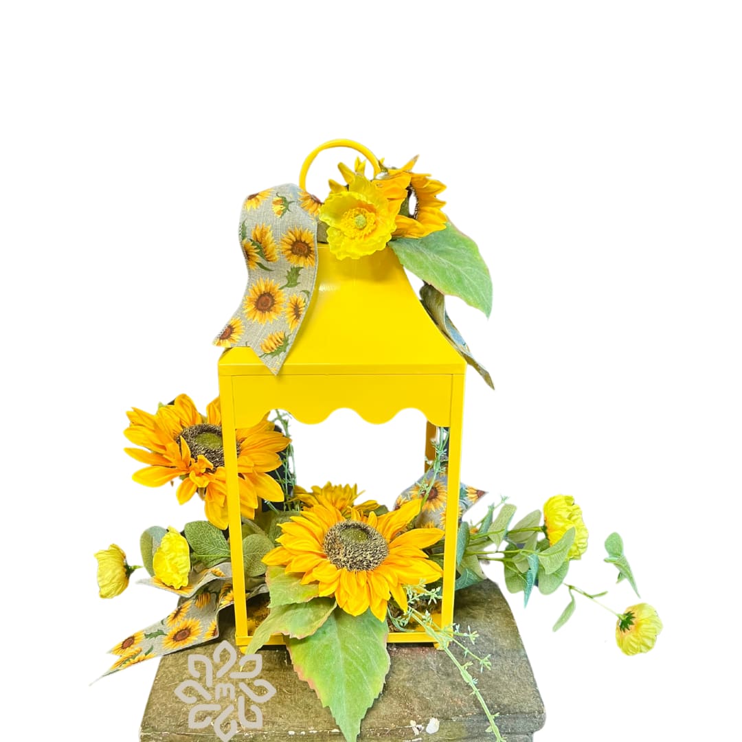 Sunny Bloom Lantern - Brighten someone's day with the &quot;Sunny Bloom Lantern,&quot; an enchanting yellow metal decorative lantern adorned with radiant silk sunflowers, lush greenery, and a charming sunflower-printed ribbon. This delightful piece is perfect for gifting, whether it's to wish someone a speedy recovery or to celebrate a birthday with a splash of sunshine.