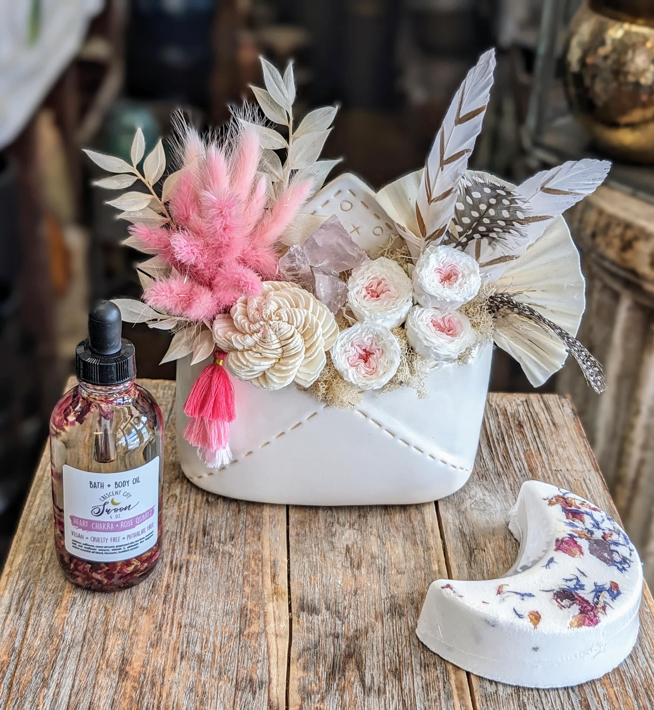 Sonnet Sonnet - Sonnet Softly spoken and artfully composed, Sonnet is a romantic floral arrangement from Windmill Floral Expressions in Las Vegas, designed like a verse in bloom. With a palette of gentle pastels and tender textures, this arrangement whispers elegance and timeless emotion. Preserved blush roses and a creamy sola wood flower form a dreamy foundation., accented by pink bunny tails, bleached ruscus, rose quartz pieces and white reindeer moss. Housed in a sweet petite ceramic envelope with refined detail, Sonnet feels like a love letter written in flowers. Perfect for anniversaries, sympathy, weddings, or any heartfelt occasion, Sonnet captures the beauty of grace in full bloom. Handcrafted with love in Las Vegas. Same-day delivery available. It also includes a Heart Chakra Rose Quartz Crystal Bath and Body Oil and a Moon Bath Crystal Bath Bomb The envelope measures approximately 6 inches wide by 7 inches tall.
