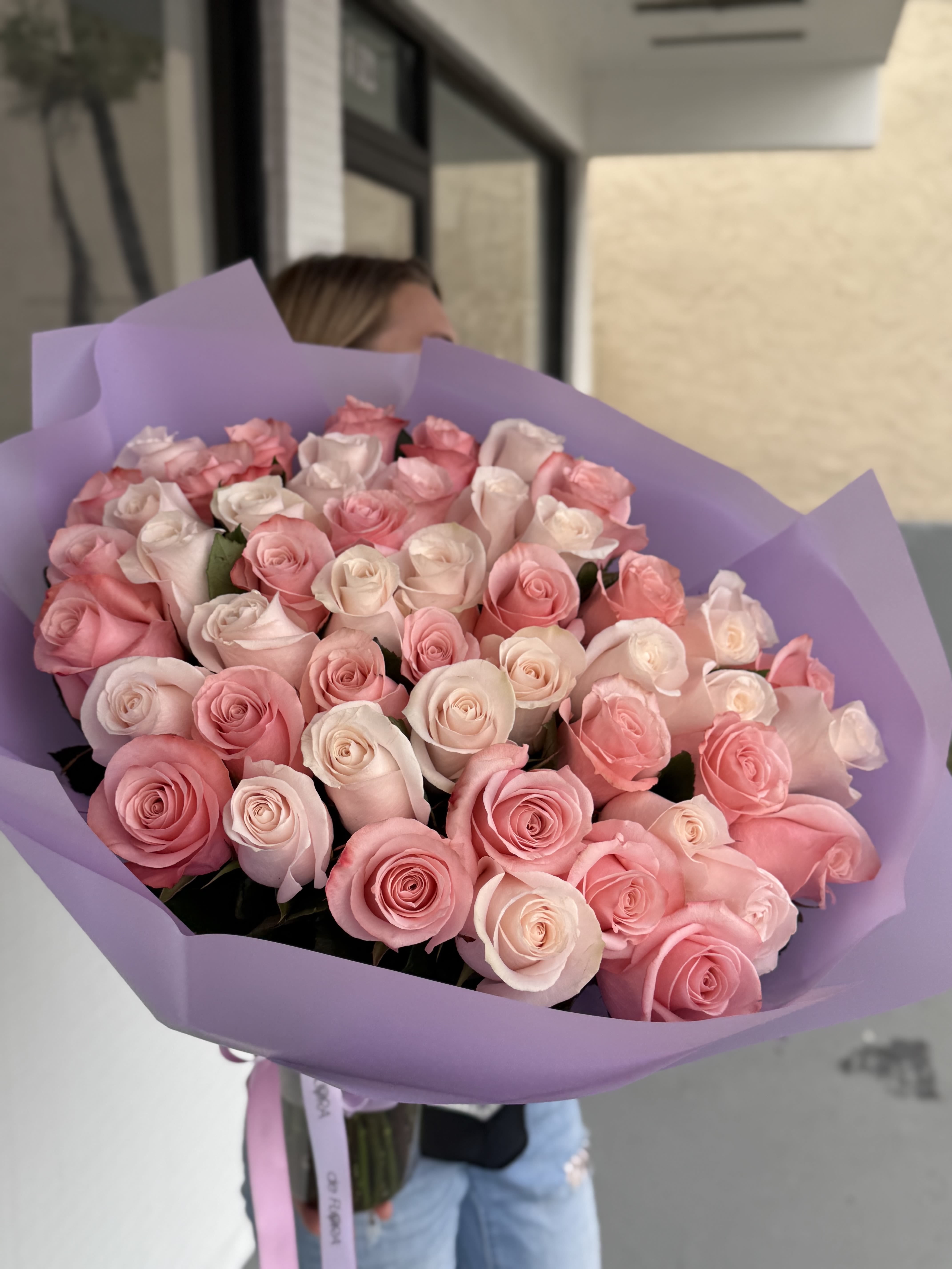 Blush Symphony - This luxurious bouquet, Blush Symphony, is a romantic medley of premium Ecuadorian roses in delicate shades of blush pink, soft ivory, and pastel peach. Each stem is carefully selected and arranged to create a harmonious flow of color, wrapped in an elegant matte lavender paper for a sophisticated finish. Perfect for anniversaries, birthdays, or heartfelt gestures, this bouquet speaks the language of tenderness, admiration, and timeless beauty. A showstopping statement of love and grace. Included with your bouquet:  Glass vase or aqua box  Protective transportation box  Greeting card  Flower food for long-lasting freshness  Free delivery (check your zip code)  Experience luxury floral gifting — made effortless.