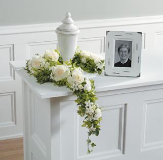 White Simplicity Urn Spray White Simplicity Urn Spray - This modern flower spray of white roses, stephanotis and ivy will add a simple but beautiful touch to the service.