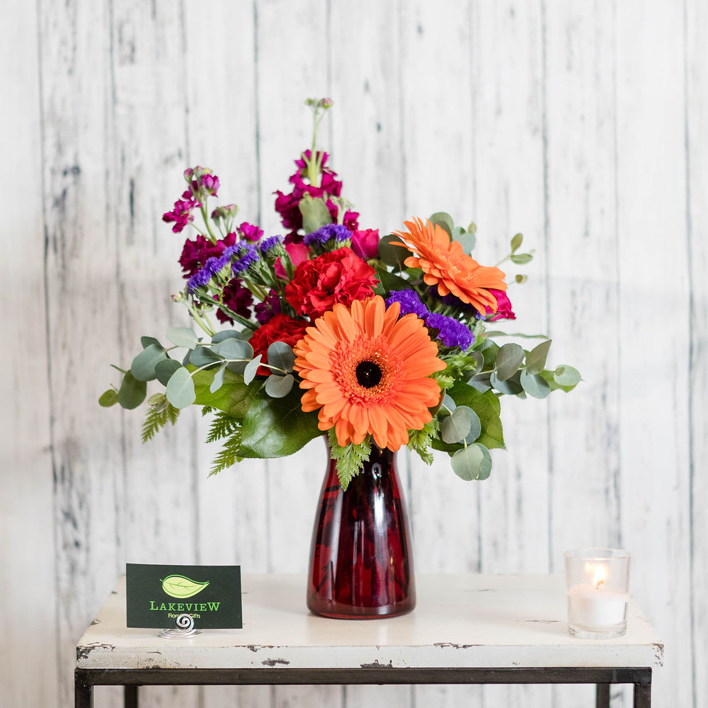 Fiery - Vibrant colors of gerbera daisies, stock and carnations will light up a desk, dorm or home!  Approximate Dimensions: 10&quot; W x 16&quot; H