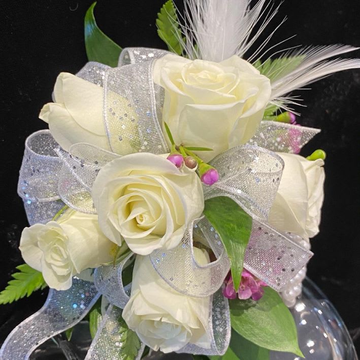Feathery White Wrist Corsage Feathery White Wrist Corsage - We take pure white spray roses, bright pink accents, a white organza ribbon and top it all off with white feathers. We love this whimsical corsage! You will too.