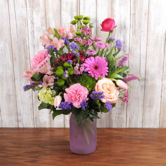 Hugs and Kisses Hugs and Kisses - A purple vase filled with flowers that is sure to make moms day! An assortment of carnations, alstroemeria, tulips and Gerber daisies.