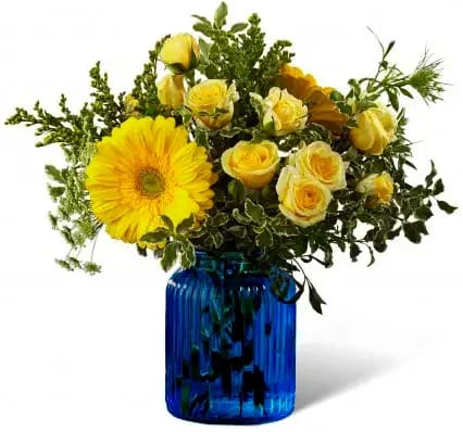  SOMETHING BLUE  [TT-SMTGBLUE] - Something Blue Bouquet.  A rush of light and sky, this gorgeous sunlit flower bouquet is ready to make that perfect impression. Considered the happiest flower on earth, yellow gerbera daisies take center stage in this flower arrangement sharing the spotlight with pale yellow spray roses, yellow snapdragons, solidago, fillers and lush greens.  Presented in a brilliant blue glass vase to make this gift boldly stand out from the rest, this flower bouquet is ready to create a winning thank you, thinking of you, engagement, or wedding gift. GOOD bouquet is approx. 12&quot;H x 12&quot;W. BETTER bouquet is approx. 13&quot;H x 13&quot;W. BEST bouquet is approx. 13&quot;H x 14&quot;W. EXQUISITE bouquet is approx. 14&quot;H x 16&quot;W. 