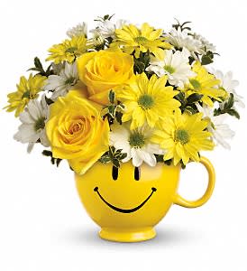 Be Happy Bouquet with Roses [T43-1A] - There are probably a million reasons this is such a popular bouquet. Of course, there are probably just as many reasons to send this cheerful arrangement. Full of happy flowers, this ceramic happy face mug will bring smiles for years to come. Especially when filled with that first cup of morning coffee or cocoa!  Yellow roses and daisy spray chrysanthemums along with white daisy spray chrysanthemums and oregonia are delivered in the one and only Be Happy® mug.  Approximately 9 1/2&quot; W x 9&quot; H  Orientation: One-Sided      As Shown : T43-1A