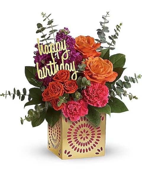 Teleflora's Birthday Sparkle Bouquet - Add some extra special sparkle to their birthday with this grand gift! Hand-delivered in a shimmering golden cube with intricate cutouts, this colorful bouquet will make their birthday week wonderful. Later, they can remove the pretty magenta liner and golden &quot;happy birthday&quot; pick and enjoy the cube as a pretty candleholder! This colorful mix features orange roses, orange spray roses, fuchsia stock, pink carnations, spiral eucalyptus and lemon leaf. Delivered in a Celebrate in Style cube.