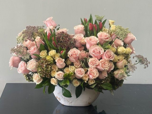 Garden Romance Garden Romance - A garden style composition is layered with soft hues of blush pinks and is complemented with yellows. The blend of deep colored greenery is accented with soft pastels. This beauty rests in a white vase for any occasion. Perfect floral recipe for a garden vibe event. Some florals are seasonal, if particular flower will not be available due to season, we will substitute for similar flower, composition, color pallet and value of the arrangements as closely as possible. All effort to create a floral arrangement as close to the photo shown, the actual arrangement may vary slightly in its appearance from the photo shown. If you have any questions about your order, we welcome you to call us in or email
