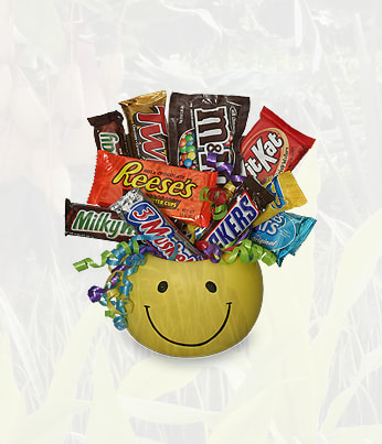 Candy Basket By Luv It - HOW COULD YOU GO WRONG WITH A BOUQUET OVERFLOWING WITH DELICIOUS SWEET TREATS! A great gift for any age... It can be perfectly paired with a plush stuffed animal or balloons. (Please remember that each selection is custom made and substitutions may be necessary. Your order will be produced as closely as possible to the picture.)  Includes: Yellow Smiley Face Bowl Or Mug,   Assorted Candy Bars,  (Shown: Reeses, Snickers, Milky Way, Kitkat, Twix, Butterfinger, M &amp; Ms, Three Musketeers).
