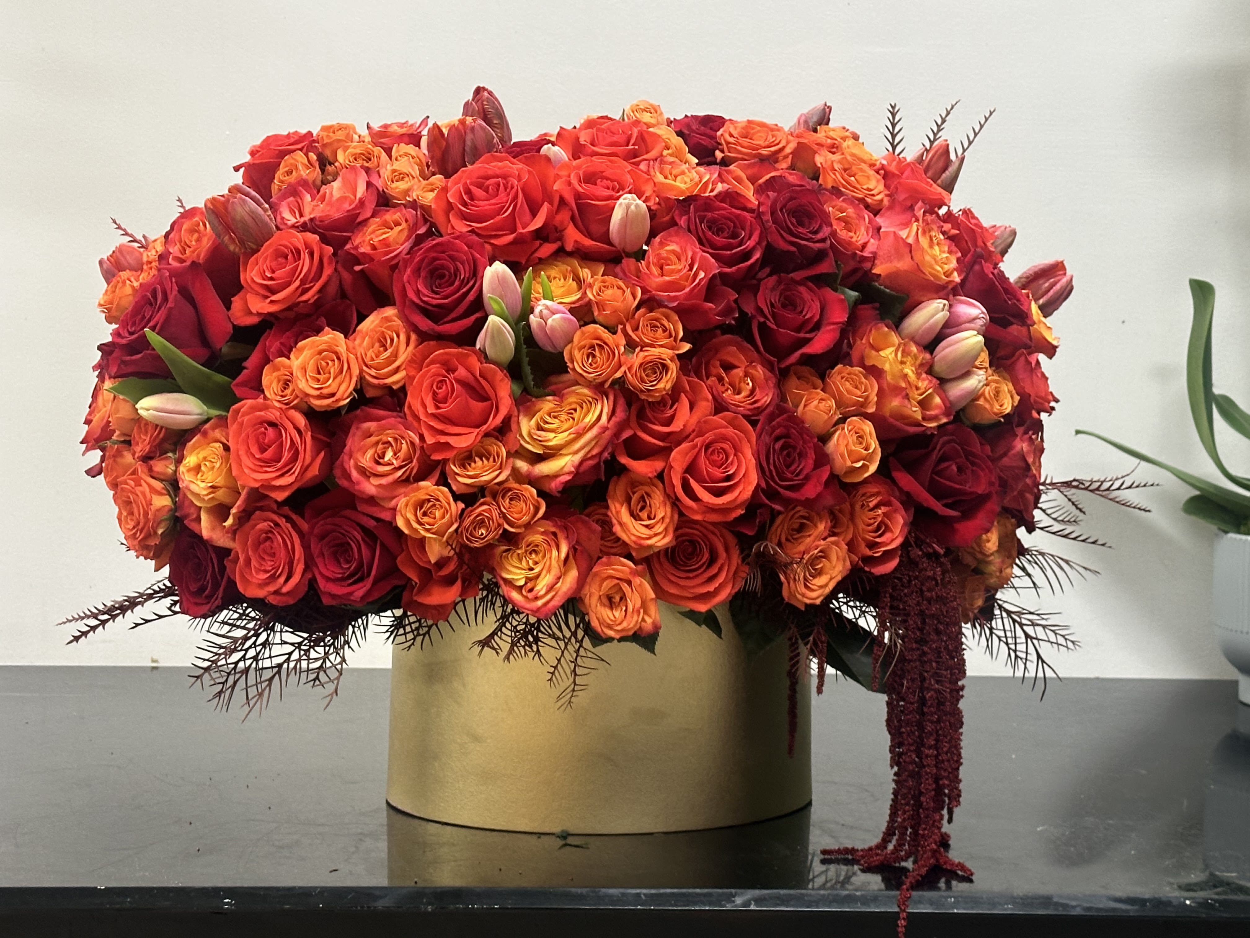 Orange Spice  - Vibrant and gorgeous floral composition features a harmonious blend of two-tone orange roses, and the orange rose. Adding rich textured deep red roses and Amaranthus for depth and drama. This designer's choice arrangement is full and dense and unveils classic drama.  Some florals are seasonal, if particular flower will not be available due to season, we will substitute for similar flower, composition, color pallet and value of the arrangements as closely as possible. All effort to create a floral arrangement as close to the photo shown, the actual arrangement may vary slightly in its appearance from the photo shown. If you have any questions about your order, we welcome you to call us in or email   