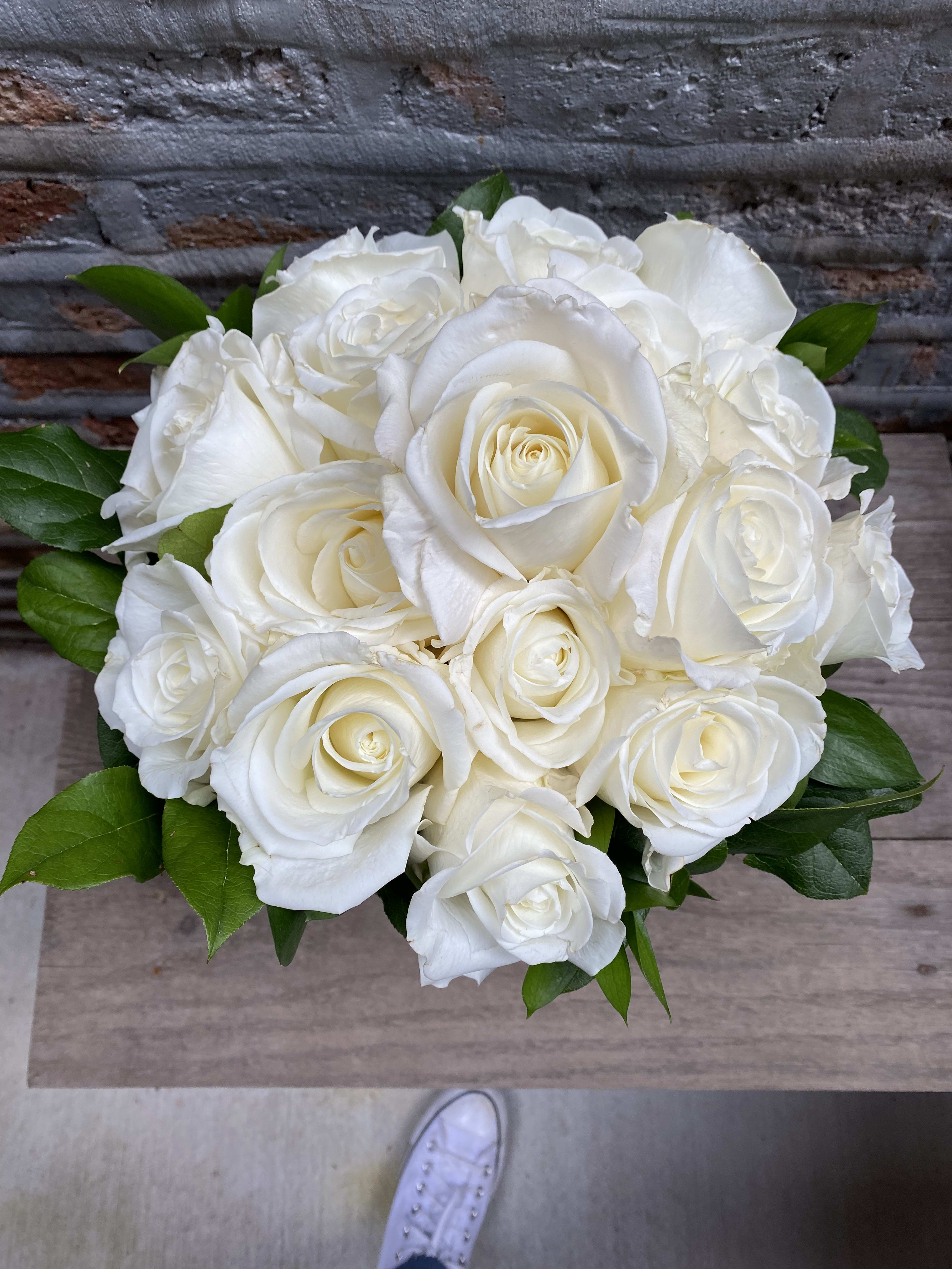 White Rose Bridal Bouquet - CALL STORE TO ORDER White Rose Bridal Bouquet - CALL STORE TO ORDER - Bridal Bouquet of Ivory Roses, collared with dark greens of ruscus and lemon leaf.
