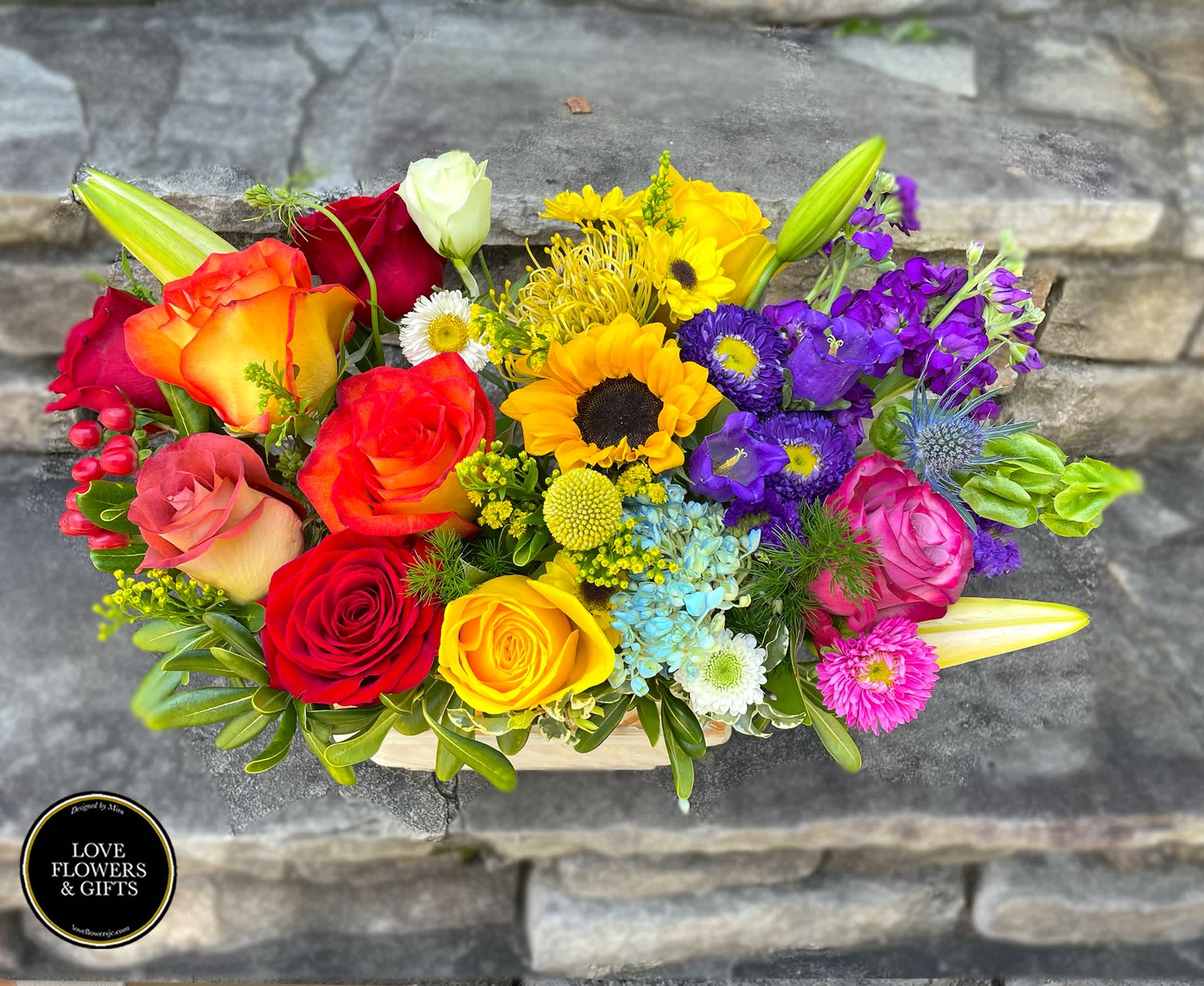 Rainbow  - A fun colorful low arrangement designed in a wide ceramic vase in rainbow assort, especially perfect for his birthdays, celebration, and get well.   Picture shown is approximately 12 by 10 inch 
