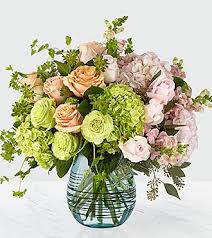 Whispers of Spring Luxury Bouquet Whispers of Spring Luxury Bouquet - Soft and alluring, this luxury flower bouquet is one of a kind that will have your special recipient take notice. Playing with a balance of colors and textures that makes this artisan floral design stand out from the rest, this fresh flower arrangement weaves together pink, peach, and green roses, with green and pink hydrangea blooms, snapdragons, bupleurum, seeded eucalyptus, and lush greens to create a stunning affect. Presented in a modern aqua blue swirled glass vase to give this bouquet a polished look, this gift of flowers is ready to create that perfect impression