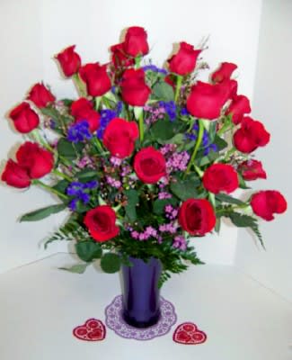Forever Love - 2 dozen long stem red roses in a premium purple glass vase with pink waxflower filler and purple statice. (Other colors available)