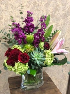 Endless Love - Type of Flowers: Purple Stock, Red Roses, Pink Stargazer, Green Hydrangeas, Fuji Mums and green succulent in a short vase. Availability: All year round Photo shown: Standard