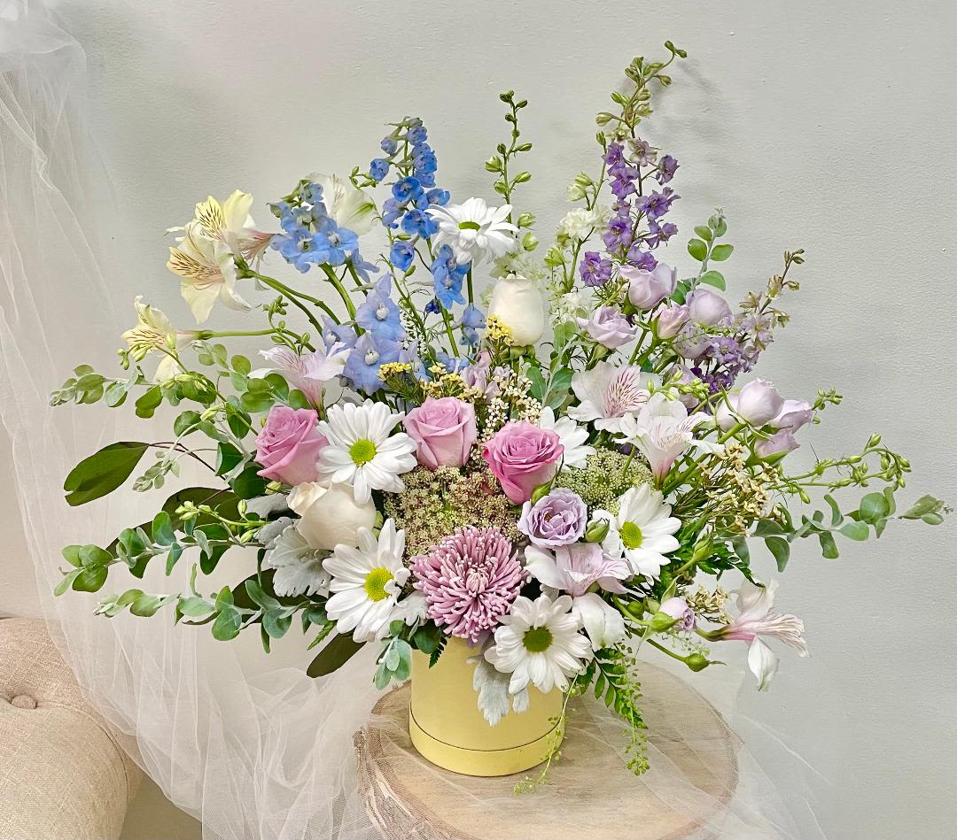 Clouded Yellow - Product Information  Product Information Theme Colors: Pastel  Featured Blooms: Roses, Delphinium, Alstroemeria, Chrysanthemums, and greeneries in Light yellow carbon box.  HK Flowers have a uniqueness of florals and seasonal blooms, certain flowers or colors may not be available as each season affects the availability, color, size, and shape of each floral bloom. Some flowers may be substituted accordingly.  Photos are used as a reference for the color palette and is NOT indicated of the final product. We ask for your trust in us that we will pick out the best seasonal available blooms, while still capturing the arrangements' theme and colors mentioned above