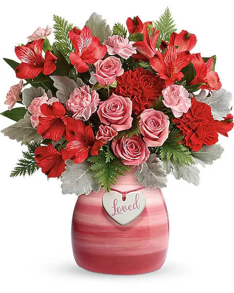 Teleflora's Playfully Pink Bouquet - Make that special someone smile with this beloved bouquet! Playful red and pink roses and radiant red blooms look oh-so wonderful in this hand-painted ceramic vase, adorned with a charming &quot;loved&quot; heart charm. This bouquet features red roses, pink spray roses, red alstroemeria, red carnations, pink miniature carnations, dusty miller, and leatherleaf fern. Delivered in a Playfully Pink vase.