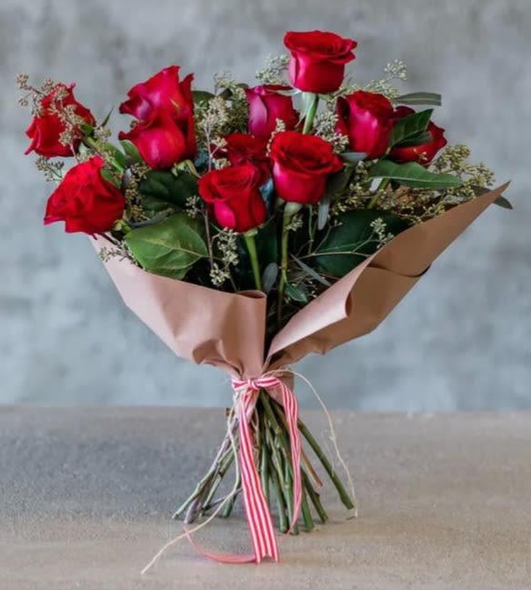 Classic Dozen Wrapped Red Roses - A dozen long stem red roses wrapped with greenery and wax flower or baby's breath.