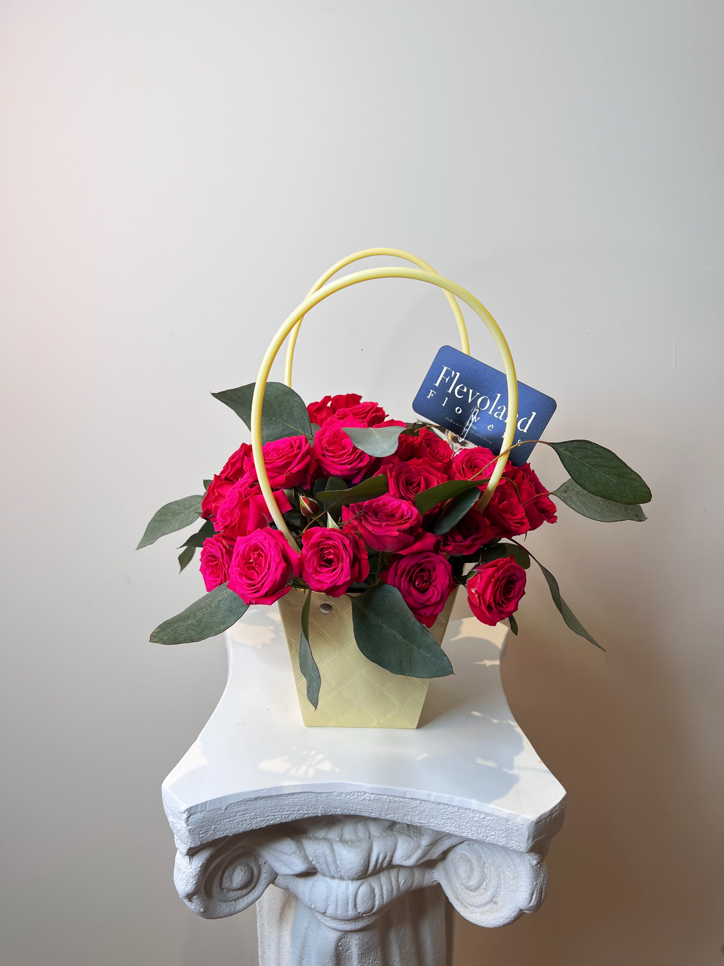 Floral Drop  - A vibrant and elegant arrangement featuring fresh mini roses and eucalyptus, designed to bring life to any space. Each piece includes a decorative base with a hidden glass container filled with water to keep the flowers fresh for longer.  Available only in May. Colors available: fuchsia, orange, and yellow. Please let us know your preferred color in the note. 