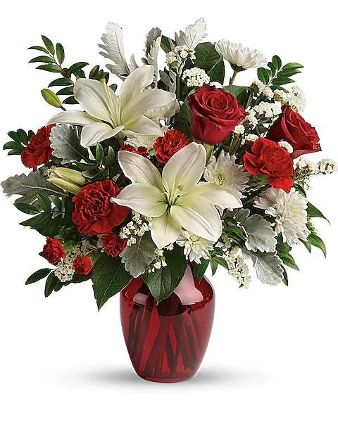 Visions Of Love Bouquet - A vision of love! This luxe bouquet of fragrant white lilies and radiant red roses, hand-delivered in a ruby vase, is the perfect expression of your feelings.  This beloved bouquet includes red roses, white asiatic lilies, red carnations, red miniature carnations, white cushion spray roses, white sinuata statice, dusty miller, huckleberry, and lemon leaf. Delivered in a ruby rose vase.