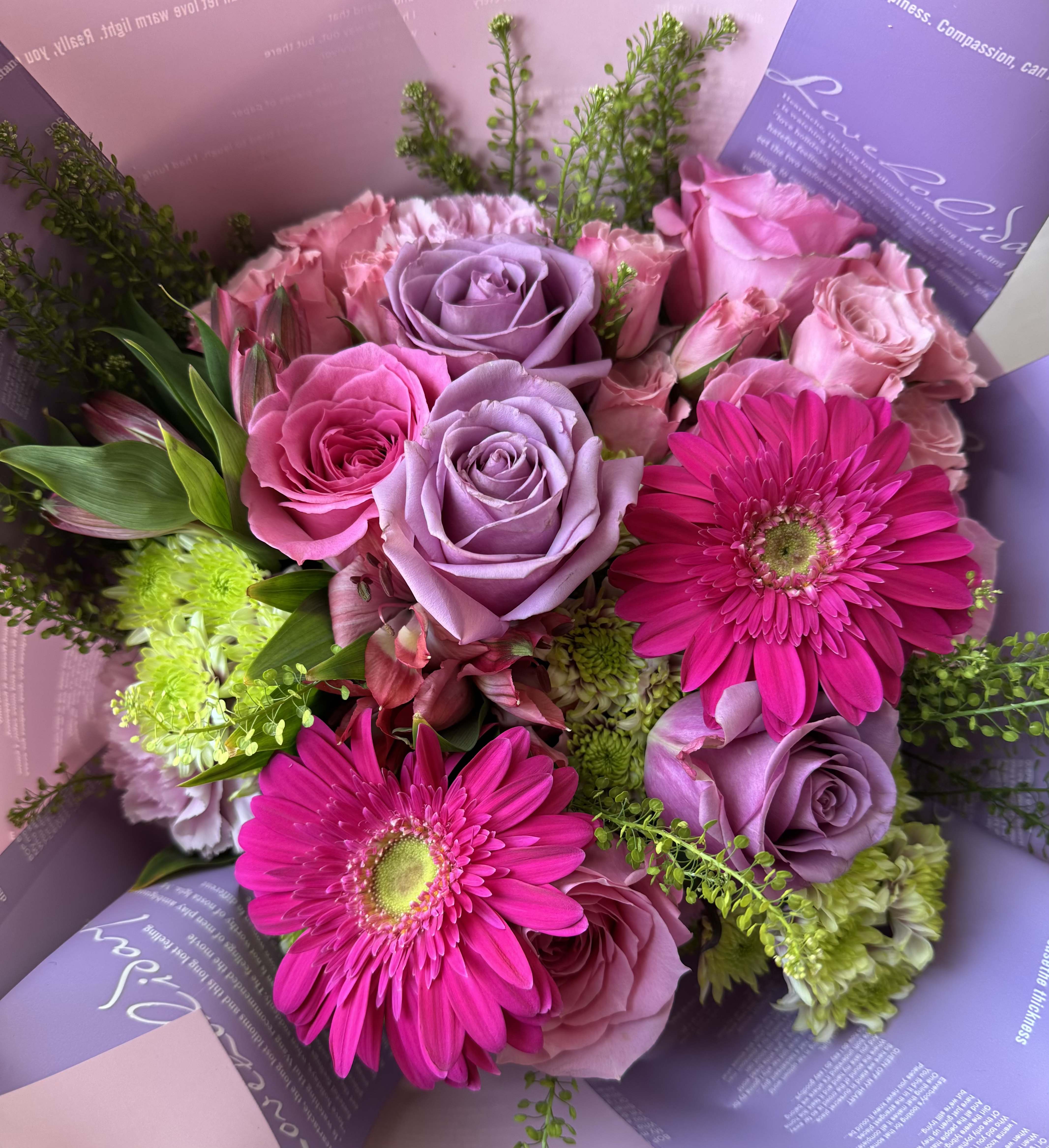 Lovely Bouquet - A charming arrangement that blends elegance and freshness. This mix of lavender and pink roses, vibrant pink gerbera daisies, and fresh green accents. All beautifully Wrapped in soft pastel paper, this bouquet is perfect for Mother's day, birthdays, anniversaries or simply to brighten someone's day!  