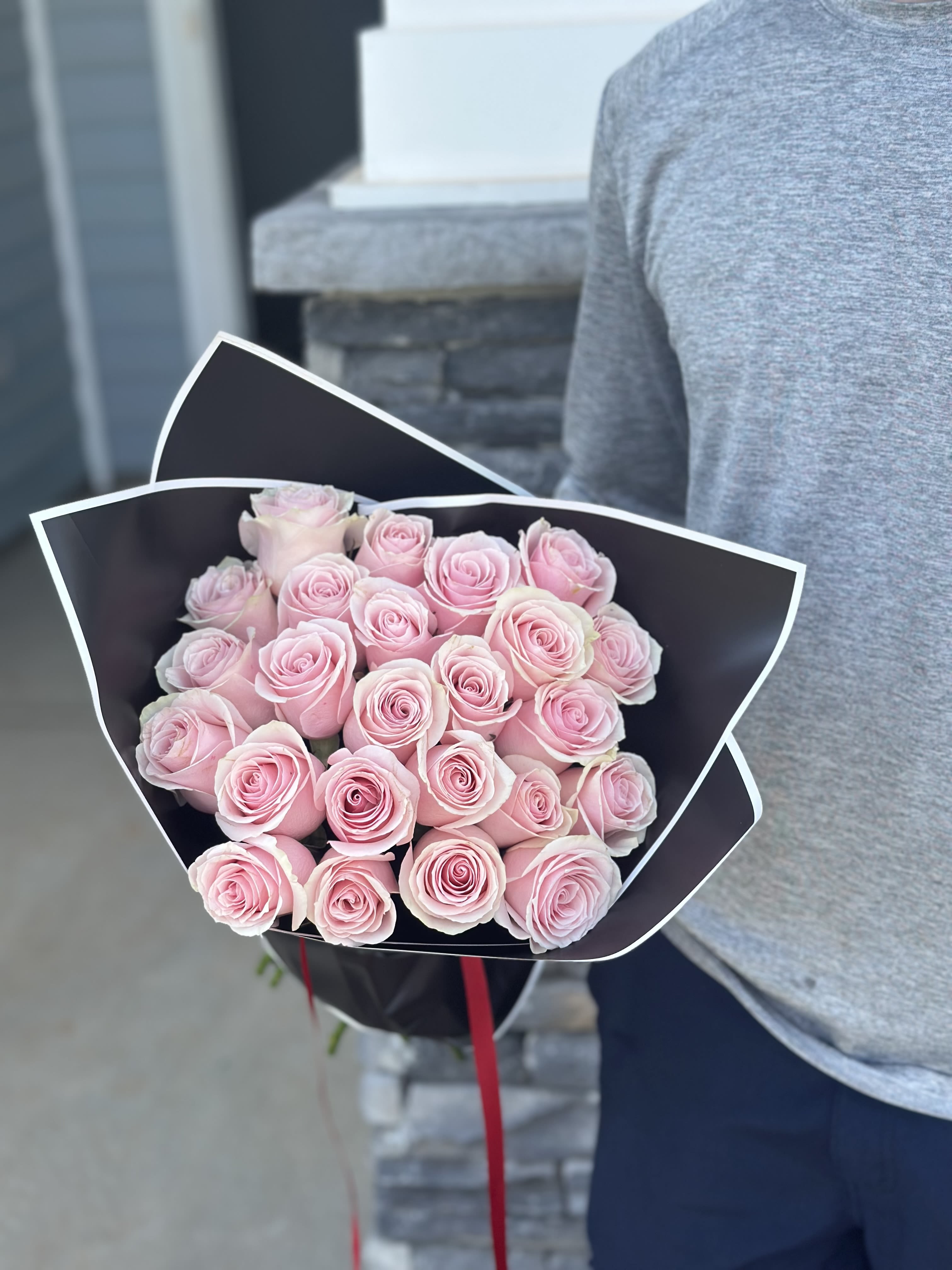 Lover’s Blush  - A bouquet that speaks the language of soft affection and romantic charm. Featuring over fifty delicate pink roses, this arrangement embodies the warmth of love and the sweetness of tender moments.  Wrapped in elegant black paper for a striking contrast, Lover’s Blush is perfect for anniversaries, heartfelt surprises, or simply to say “I adore you.” Let every rose whisper a promise of love.