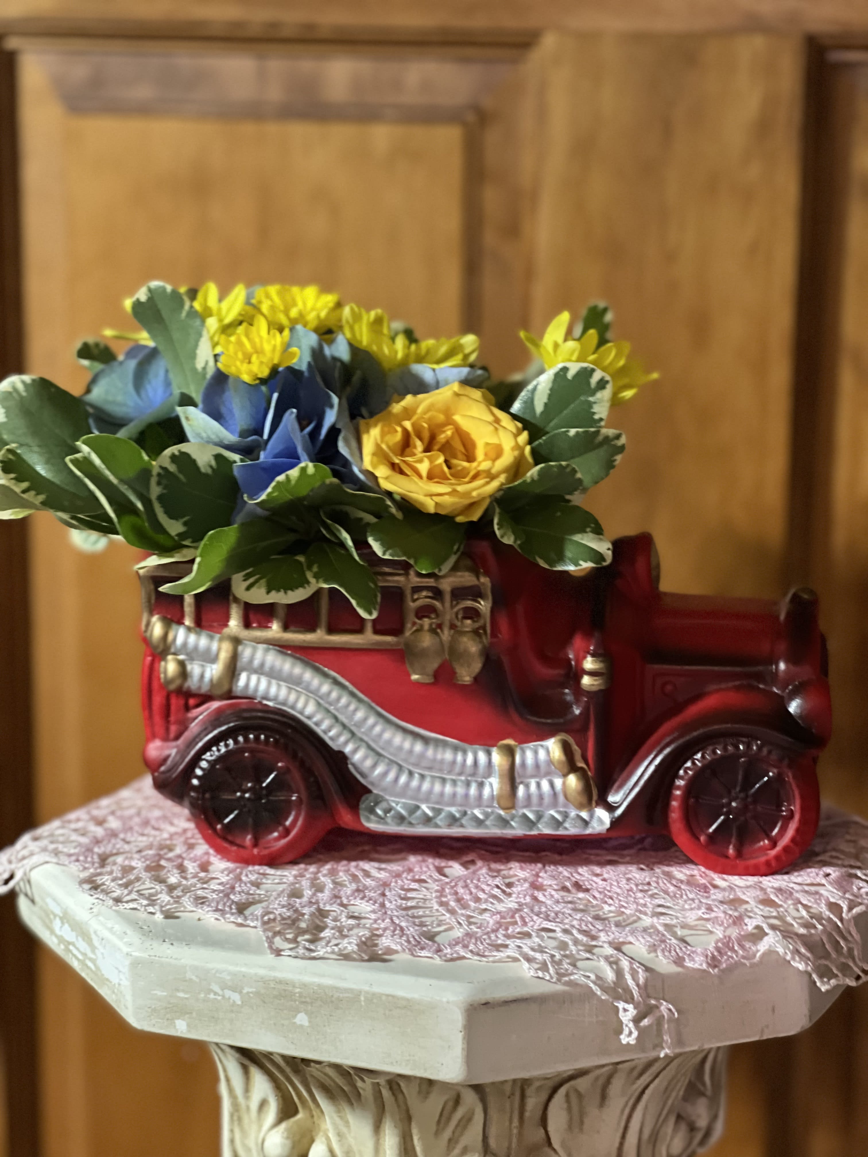 Antique Firetruck - Our Antique Firetruck is sure to warm the hearts of anyone who receives it. A wonderful keepsake for Father's Day, Birthday, or any special event or Holiday. Created in a ceramic firetruck with ladders and hoses attached. Filled with the freshest flowers for the season. May contain: Hydrangeas, spray roses, chrysanthemums, and variegated pittosporum.  Inventory count: 2
