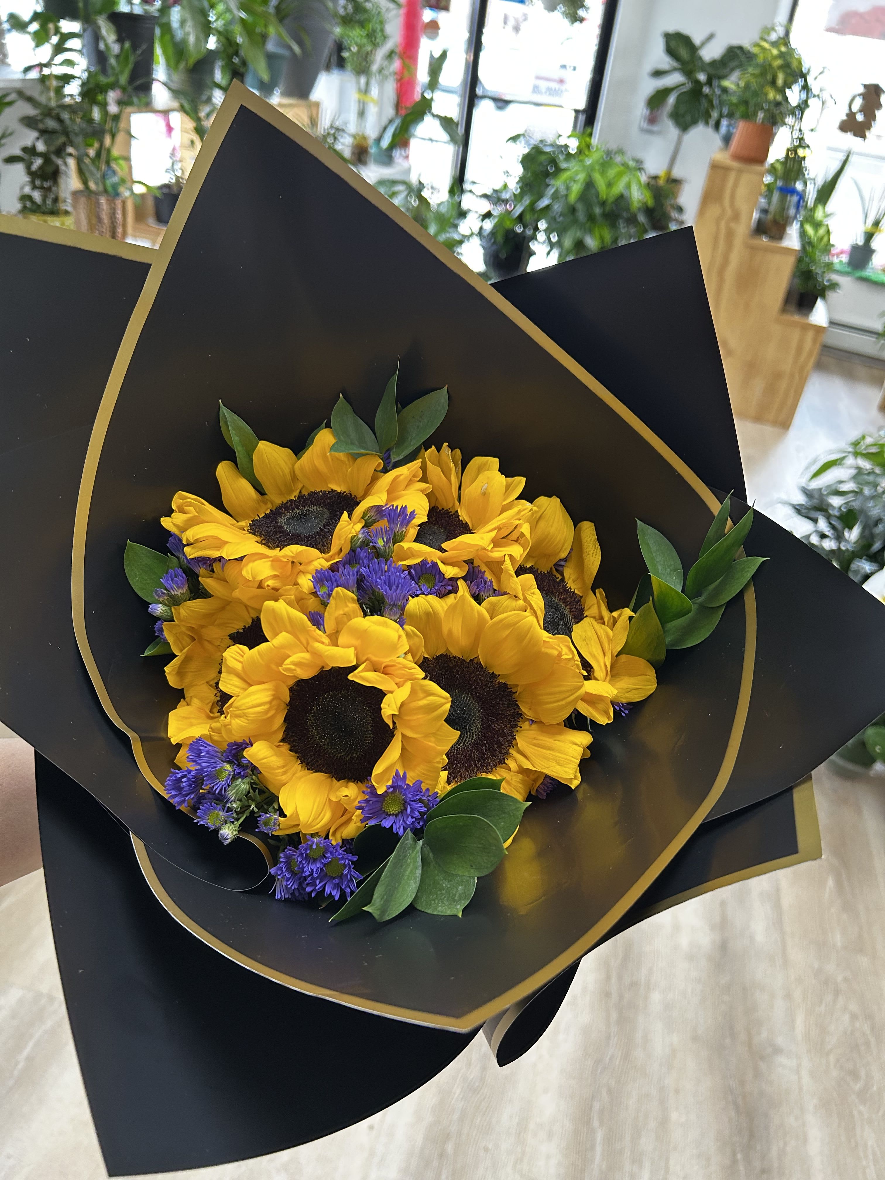 Sunflower Bouquet Sunflower Bouquet - This bouquet features sunflowers, purple aster detailed with ruscus.