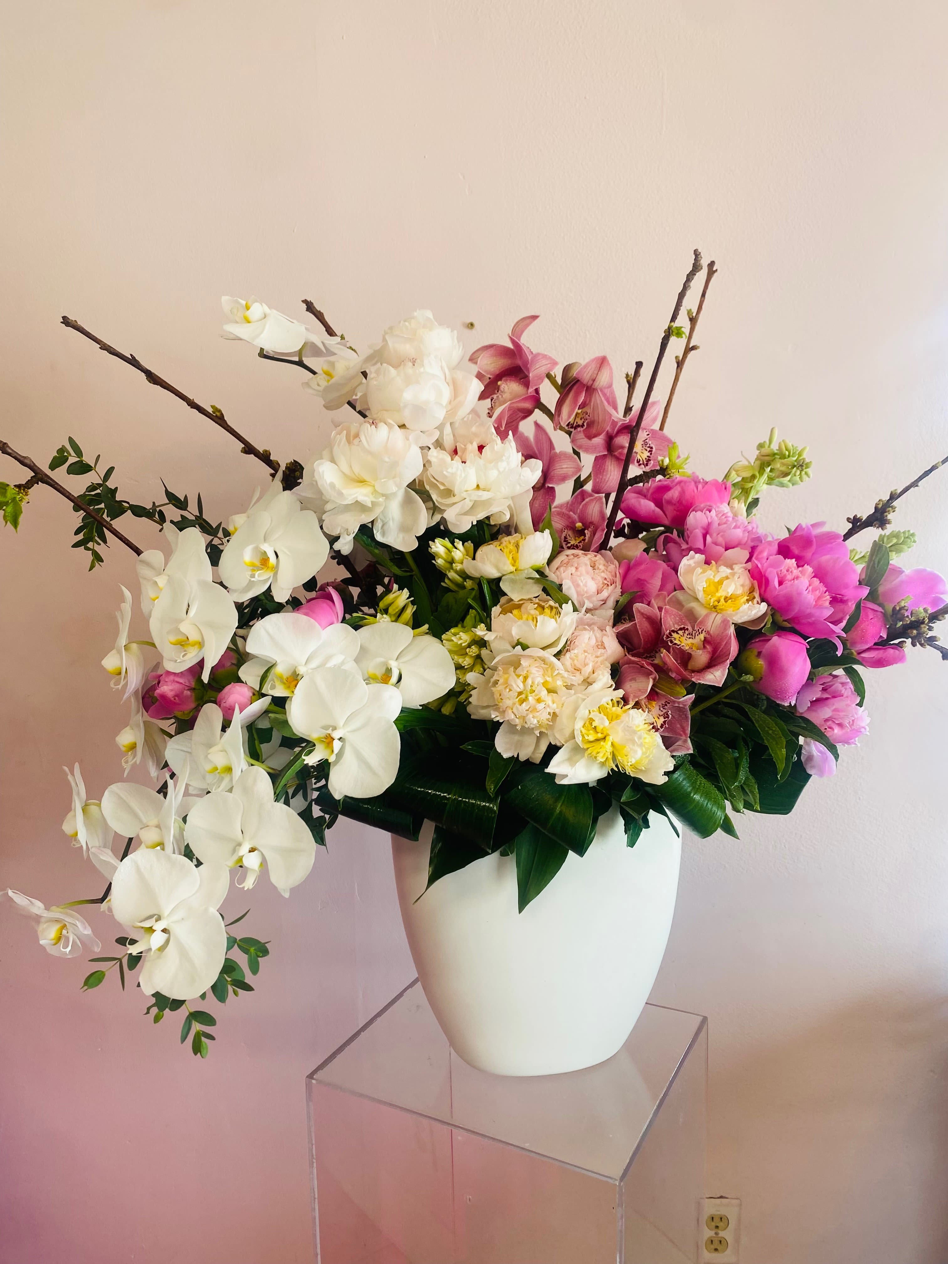 Poppies in Pink  - An ultra array of wonder and marvel. Pink and white peonies, poppies, tuberose, pink cymbidium orchids, and a cascading layer of white phalenopsis flowers. Adorned with seasonal branches, and aspidistra leaves. 